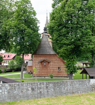 Zdjęcie nr 14: Kościół jednonawowy,  prezbiterium oddzielone ścianą tęczową z poprzeczną belką. Stropy pokryte dekoracją malarską imitującą kasetony z rozetami, z przedstawieniem Matki Boskiej z Dzieciątkiem w prezbiterium, św. Michała Archanioła w nawie oraz klęczących aniołów na ścianach. W dolnej partii ściany niebieskie, z biegnącą dookoła inskrypcją, a do jednej trzeciej wysokości od dołu w kolorze drewna. W przedsionku polichromia patronowa o motywach geometrycznych, roślinnych, zwierzęcych itd.  W nawie od zachodu chór muzyczny z dekoracją malarską roślinną i antropomorficzną. Nawa i prezbiterium naryte pozornym sklepieniem w kształcie spłaszczonej kolebki ze skośnymi fasetami. W nawie głównej jedno duże okno w kształcie stojącego prostokąta, bliżej chóru drugie, niewielkie, w kształcie leżącego; kolejne w wieży, przedsionku i prezbiterium. Główne wejście od zachodu, drugie przez kruchtę od południa, trzecie do zakrystii. Portal południowy prostokątny, osłonięty daszkiem, poniżej trójkątnego szczytu wypełnionego oknem. Od zachodu kwadratowa wieża o pochyłych ścianach pobitych gontem, z nadwieszoną, nieco występującą izbicą szalowaną pionowymi deskami, na dolnych końcach ozdobnie wycinanymi. Ściany obłożone gontem, gładkie. Nad nawą i prezbiterium dach jednokalenicowy, gontowy, wieża z ostrosłupowym hełmem. Nad nawą barokowa wieżyczka na sygnaturkę kryta blachą. 
Najcenniejszym elementem wyposażenia jest gotyckie retabulum ołtarzowe pełniące od 1935 roku rolę ołtarza głównego w miejsce rozebranego, barokowego. Oprócz niego szczególne znaczenie mają fragmenty zachowanej polichromii patronowej z około 1500 roku. 
