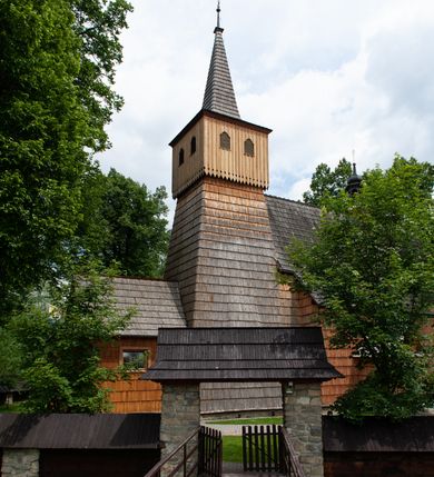 Zdjęcie nr 6: Kościół jednonawowy,  prezbiterium oddzielone ścianą tęczową z poprzeczną belką. Stropy pokryte dekoracją malarską imitującą kasetony z rozetami, z przedstawieniem Matki Boskiej z Dzieciątkiem w prezbiterium, św. Michała Archanioła w nawie oraz klęczących aniołów na ścianach. W dolnej partii ściany niebieskie, z biegnącą dookoła inskrypcją, a do jednej trzeciej wysokości od dołu w kolorze drewna. W przedsionku polichromia patronowa o motywach geometrycznych, roślinnych, zwierzęcych itd.  W nawie od zachodu chór muzyczny z dekoracją malarską roślinną i antropomorficzną. Nawa i prezbiterium naryte pozornym sklepieniem w kształcie spłaszczonej kolebki ze skośnymi fasetami. W nawie głównej jedno duże okno w kształcie stojącego prostokąta, bliżej chóru drugie, niewielkie, w kształcie leżącego; kolejne w wieży, przedsionku i prezbiterium. Główne wejście od zachodu, drugie przez kruchtę od południa, trzecie do zakrystii. Portal południowy prostokątny, osłonięty daszkiem, poniżej trójkątnego szczytu wypełnionego oknem. Od zachodu kwadratowa wieża o pochyłych ścianach pobitych gontem, z nadwieszoną, nieco występującą izbicą szalowaną pionowymi deskami, na dolnych końcach ozdobnie wycinanymi. Ściany obłożone gontem, gładkie. Nad nawą i prezbiterium dach jednokalenicowy, gontowy, wieża z ostrosłupowym hełmem. Nad nawą barokowa wieżyczka na sygnaturkę kryta blachą. 
Najcenniejszym elementem wyposażenia jest gotyckie retabulum ołtarzowe pełniące od 1935 roku rolę ołtarza głównego w miejsce rozebranego, barokowego. Oprócz niego szczególne znaczenie mają fragmenty zachowanej polichromii patronowej z około 1500 roku. 
