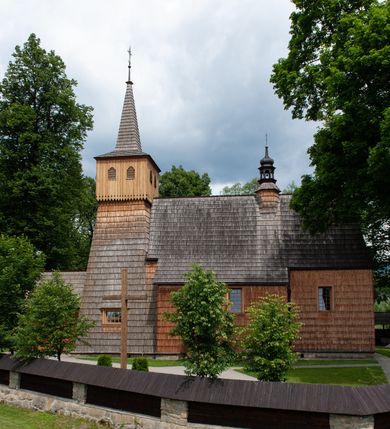 Zdjęcie nr 7: Kościół jednonawowy,  prezbiterium oddzielone ścianą tęczową z poprzeczną belką. Stropy pokryte dekoracją malarską imitującą kasetony z rozetami, z przedstawieniem Matki Boskiej z Dzieciątkiem w prezbiterium, św. Michała Archanioła w nawie oraz klęczących aniołów na ścianach. W dolnej partii ściany niebieskie, z biegnącą dookoła inskrypcją, a do jednej trzeciej wysokości od dołu w kolorze drewna. W przedsionku polichromia patronowa o motywach geometrycznych, roślinnych, zwierzęcych itd.  W nawie od zachodu chór muzyczny z dekoracją malarską roślinną i antropomorficzną. Nawa i prezbiterium naryte pozornym sklepieniem w kształcie spłaszczonej kolebki ze skośnymi fasetami. W nawie głównej jedno duże okno w kształcie stojącego prostokąta, bliżej chóru drugie, niewielkie, w kształcie leżącego; kolejne w wieży, przedsionku i prezbiterium. Główne wejście od zachodu, drugie przez kruchtę od południa, trzecie do zakrystii. Portal południowy prostokątny, osłonięty daszkiem, poniżej trójkątnego szczytu wypełnionego oknem. Od zachodu kwadratowa wieża o pochyłych ścianach pobitych gontem, z nadwieszoną, nieco występującą izbicą szalowaną pionowymi deskami, na dolnych końcach ozdobnie wycinanymi. Ściany obłożone gontem, gładkie. Nad nawą i prezbiterium dach jednokalenicowy, gontowy, wieża z ostrosłupowym hełmem. Nad nawą barokowa wieżyczka na sygnaturkę kryta blachą. 
Najcenniejszym elementem wyposażenia jest gotyckie retabulum ołtarzowe pełniące od 1935 roku rolę ołtarza głównego w miejsce rozebranego, barokowego. Oprócz niego szczególne znaczenie mają fragmenty zachowanej polichromii patronowej z około 1500 roku. 
