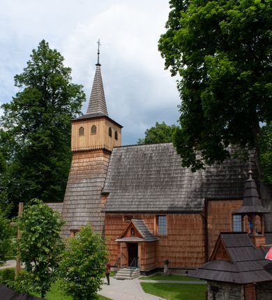 Zdjęcie nr 9: Kościół jednonawowy,  prezbiterium oddzielone ścianą tęczową z poprzeczną belką. Stropy pokryte dekoracją malarską imitującą kasetony z rozetami, z przedstawieniem Matki Boskiej z Dzieciątkiem w prezbiterium, św. Michała Archanioła w nawie oraz klęczących aniołów na ścianach. W dolnej partii ściany niebieskie, z biegnącą dookoła inskrypcją, a do jednej trzeciej wysokości od dołu w kolorze drewna. W przedsionku polichromia patronowa o motywach geometrycznych, roślinnych, zwierzęcych itd.  W nawie od zachodu chór muzyczny z dekoracją malarską roślinną i antropomorficzną. Nawa i prezbiterium naryte pozornym sklepieniem w kształcie spłaszczonej kolebki ze skośnymi fasetami. W nawie głównej jedno duże okno w kształcie stojącego prostokąta, bliżej chóru drugie, niewielkie, w kształcie leżącego; kolejne w wieży, przedsionku i prezbiterium. Główne wejście od zachodu, drugie przez kruchtę od południa, trzecie do zakrystii. Portal południowy prostokątny, osłonięty daszkiem, poniżej trójkątnego szczytu wypełnionego oknem. Od zachodu kwadratowa wieża o pochyłych ścianach pobitych gontem, z nadwieszoną, nieco występującą izbicą szalowaną pionowymi deskami, na dolnych końcach ozdobnie wycinanymi. Ściany obłożone gontem, gładkie. Nad nawą i prezbiterium dach jednokalenicowy, gontowy, wieża z ostrosłupowym hełmem. Nad nawą barokowa wieżyczka na sygnaturkę kryta blachą. 
Najcenniejszym elementem wyposażenia jest gotyckie retabulum ołtarzowe pełniące od 1935 roku rolę ołtarza głównego w miejsce rozebranego, barokowego. Oprócz niego szczególne znaczenie mają fragmenty zachowanej polichromii patronowej z około 1500 roku. 
