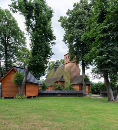 Zdjęcie nr 20: Kościół jednonawowy,  prezbiterium oddzielone ścianą tęczową z poprzeczną belką. Stropy pokryte dekoracją malarską imitującą kasetony z rozetami, z przedstawieniem Matki Boskiej z Dzieciątkiem w prezbiterium, św. Michała Archanioła w nawie oraz klęczących aniołów na ścianach. W dolnej partii ściany niebieskie, z biegnącą dookoła inskrypcją, a do jednej trzeciej wysokości od dołu w kolorze drewna. W przedsionku polichromia patronowa o motywach geometrycznych, roślinnych, zwierzęcych itd.  W nawie od zachodu chór muzyczny z dekoracją malarską roślinną i antropomorficzną. Nawa i prezbiterium naryte pozornym sklepieniem w kształcie spłaszczonej kolebki ze skośnymi fasetami. W nawie głównej jedno duże okno w kształcie stojącego prostokąta, bliżej chóru drugie, niewielkie, w kształcie leżącego; kolejne w wieży, przedsionku i prezbiterium. Główne wejście od zachodu, drugie przez kruchtę od południa, trzecie do zakrystii. Portal południowy prostokątny, osłonięty daszkiem, poniżej trójkątnego szczytu wypełnionego oknem. Od zachodu kwadratowa wieża o pochyłych ścianach pobitych gontem, z nadwieszoną, nieco występującą izbicą szalowaną pionowymi deskami, na dolnych końcach ozdobnie wycinanymi. Ściany obłożone gontem, gładkie. Nad nawą i prezbiterium dach jednokalenicowy, gontowy, wieża z ostrosłupowym hełmem. Nad nawą barokowa wieżyczka na sygnaturkę kryta blachą. 
Najcenniejszym elementem wyposażenia jest gotyckie retabulum ołtarzowe pełniące od 1935 roku rolę ołtarza głównego w miejsce rozebranego, barokowego. Oprócz niego szczególne znaczenie mają fragmenty zachowanej polichromii patronowej z około 1500 roku. 
