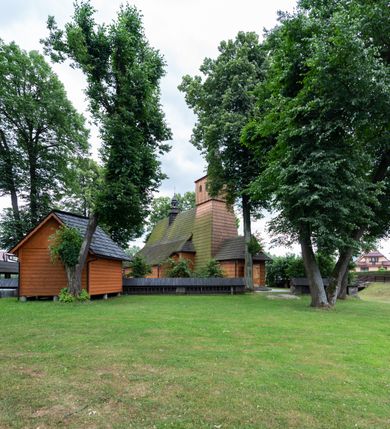 Zdjęcie nr 21: Kościół jednonawowy,  prezbiterium oddzielone ścianą tęczową z poprzeczną belką. Stropy pokryte dekoracją malarską imitującą kasetony z rozetami, z przedstawieniem Matki Boskiej z Dzieciątkiem w prezbiterium, św. Michała Archanioła w nawie oraz klęczących aniołów na ścianach. W dolnej partii ściany niebieskie, z biegnącą dookoła inskrypcją, a do jednej trzeciej wysokości od dołu w kolorze drewna. W przedsionku polichromia patronowa o motywach geometrycznych, roślinnych, zwierzęcych itd.  W nawie od zachodu chór muzyczny z dekoracją malarską roślinną i antropomorficzną. Nawa i prezbiterium naryte pozornym sklepieniem w kształcie spłaszczonej kolebki ze skośnymi fasetami. W nawie głównej jedno duże okno w kształcie stojącego prostokąta, bliżej chóru drugie, niewielkie, w kształcie leżącego; kolejne w wieży, przedsionku i prezbiterium. Główne wejście od zachodu, drugie przez kruchtę od południa, trzecie do zakrystii. Portal południowy prostokątny, osłonięty daszkiem, poniżej trójkątnego szczytu wypełnionego oknem. Od zachodu kwadratowa wieża o pochyłych ścianach pobitych gontem, z nadwieszoną, nieco występującą izbicą szalowaną pionowymi deskami, na dolnych końcach ozdobnie wycinanymi. Ściany obłożone gontem, gładkie. Nad nawą i prezbiterium dach jednokalenicowy, gontowy, wieża z ostrosłupowym hełmem. Nad nawą barokowa wieżyczka na sygnaturkę kryta blachą. 
Najcenniejszym elementem wyposażenia jest gotyckie retabulum ołtarzowe pełniące od 1935 roku rolę ołtarza głównego w miejsce rozebranego, barokowego. Oprócz niego szczególne znaczenie mają fragmenty zachowanej polichromii patronowej z około 1500 roku. 
