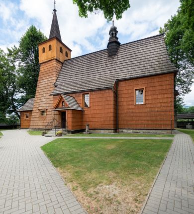 Zdjęcie nr 10: Kościół jednonawowy,  prezbiterium oddzielone ścianą tęczową z poprzeczną belką. Stropy pokryte dekoracją malarską imitującą kasetony z rozetami, z przedstawieniem Matki Boskiej z Dzieciątkiem w prezbiterium, św. Michała Archanioła w nawie oraz klęczących aniołów na ścianach. W dolnej partii ściany niebieskie, z biegnącą dookoła inskrypcją, a do jednej trzeciej wysokości od dołu w kolorze drewna. W przedsionku polichromia patronowa o motywach geometrycznych, roślinnych, zwierzęcych itd.  W nawie od zachodu chór muzyczny z dekoracją malarską roślinną i antropomorficzną. Nawa i prezbiterium naryte pozornym sklepieniem w kształcie spłaszczonej kolebki ze skośnymi fasetami. W nawie głównej jedno duże okno w kształcie stojącego prostokąta, bliżej chóru drugie, niewielkie, w kształcie leżącego; kolejne w wieży, przedsionku i prezbiterium. Główne wejście od zachodu, drugie przez kruchtę od południa, trzecie do zakrystii. Portal południowy prostokątny, osłonięty daszkiem, poniżej trójkątnego szczytu wypełnionego oknem. Od zachodu kwadratowa wieża o pochyłych ścianach pobitych gontem, z nadwieszoną, nieco występującą izbicą szalowaną pionowymi deskami, na dolnych końcach ozdobnie wycinanymi. Ściany obłożone gontem, gładkie. Nad nawą i prezbiterium dach jednokalenicowy, gontowy, wieża z ostrosłupowym hełmem. Nad nawą barokowa wieżyczka na sygnaturkę kryta blachą. 
Najcenniejszym elementem wyposażenia jest gotyckie retabulum ołtarzowe pełniące od 1935 roku rolę ołtarza głównego w miejsce rozebranego, barokowego. Oprócz niego szczególne znaczenie mają fragmenty zachowanej polichromii patronowej z około 1500 roku. 
