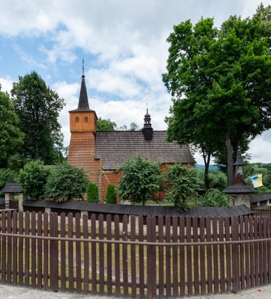 Zdjęcie nr 27: Kościół jednonawowy,  prezbiterium oddzielone ścianą tęczową z poprzeczną belką. Stropy pokryte dekoracją malarską imitującą kasetony z rozetami, z przedstawieniem Matki Boskiej z Dzieciątkiem w prezbiterium, św. Michała Archanioła w nawie oraz klęczących aniołów na ścianach. W dolnej partii ściany niebieskie, z biegnącą dookoła inskrypcją, a do jednej trzeciej wysokości od dołu w kolorze drewna. W przedsionku polichromia patronowa o motywach geometrycznych, roślinnych, zwierzęcych itd.  W nawie od zachodu chór muzyczny z dekoracją malarską roślinną i antropomorficzną. Nawa i prezbiterium naryte pozornym sklepieniem w kształcie spłaszczonej kolebki ze skośnymi fasetami. W nawie głównej jedno duże okno w kształcie stojącego prostokąta, bliżej chóru drugie, niewielkie, w kształcie leżącego; kolejne w wieży, przedsionku i prezbiterium. Główne wejście od zachodu, drugie przez kruchtę od południa, trzecie do zakrystii. Portal południowy prostokątny, osłonięty daszkiem, poniżej trójkątnego szczytu wypełnionego oknem. Od zachodu kwadratowa wieża o pochyłych ścianach pobitych gontem, z nadwieszoną, nieco występującą izbicą szalowaną pionowymi deskami, na dolnych końcach ozdobnie wycinanymi. Ściany obłożone gontem, gładkie. Nad nawą i prezbiterium dach jednokalenicowy, gontowy, wieża z ostrosłupowym hełmem. Nad nawą barokowa wieżyczka na sygnaturkę kryta blachą. 
Najcenniejszym elementem wyposażenia jest gotyckie retabulum ołtarzowe pełniące od 1935 roku rolę ołtarza głównego w miejsce rozebranego, barokowego. Oprócz niego szczególne znaczenie mają fragmenty zachowanej polichromii patronowej z około 1500 roku. 
