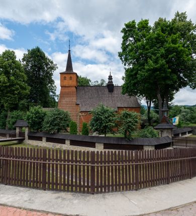 Zdjęcie nr 26: Kościół jednonawowy,  prezbiterium oddzielone ścianą tęczową z poprzeczną belką. Stropy pokryte dekoracją malarską imitującą kasetony z rozetami, z przedstawieniem Matki Boskiej z Dzieciątkiem w prezbiterium, św. Michała Archanioła w nawie oraz klęczących aniołów na ścianach. W dolnej partii ściany niebieskie, z biegnącą dookoła inskrypcją, a do jednej trzeciej wysokości od dołu w kolorze drewna. W przedsionku polichromia patronowa o motywach geometrycznych, roślinnych, zwierzęcych itd.  W nawie od zachodu chór muzyczny z dekoracją malarską roślinną i antropomorficzną. Nawa i prezbiterium naryte pozornym sklepieniem w kształcie spłaszczonej kolebki ze skośnymi fasetami. W nawie głównej jedno duże okno w kształcie stojącego prostokąta, bliżej chóru drugie, niewielkie, w kształcie leżącego; kolejne w wieży, przedsionku i prezbiterium. Główne wejście od zachodu, drugie przez kruchtę od południa, trzecie do zakrystii. Portal południowy prostokątny, osłonięty daszkiem, poniżej trójkątnego szczytu wypełnionego oknem. Od zachodu kwadratowa wieża o pochyłych ścianach pobitych gontem, z nadwieszoną, nieco występującą izbicą szalowaną pionowymi deskami, na dolnych końcach ozdobnie wycinanymi. Ściany obłożone gontem, gładkie. Nad nawą i prezbiterium dach jednokalenicowy, gontowy, wieża z ostrosłupowym hełmem. Nad nawą barokowa wieżyczka na sygnaturkę kryta blachą. 
Najcenniejszym elementem wyposażenia jest gotyckie retabulum ołtarzowe pełniące od 1935 roku rolę ołtarza głównego w miejsce rozebranego, barokowego. Oprócz niego szczególne znaczenie mają fragmenty zachowanej polichromii patronowej z około 1500 roku. 
