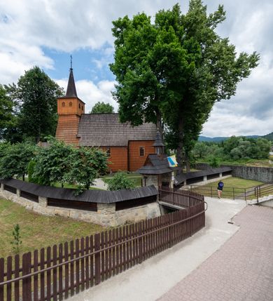 Zdjęcie nr 28: Kościół jednonawowy,  prezbiterium oddzielone ścianą tęczową z poprzeczną belką. Stropy pokryte dekoracją malarską imitującą kasetony z rozetami, z przedstawieniem Matki Boskiej z Dzieciątkiem w prezbiterium, św. Michała Archanioła w nawie oraz klęczących aniołów na ścianach. W dolnej partii ściany niebieskie, z biegnącą dookoła inskrypcją, a do jednej trzeciej wysokości od dołu w kolorze drewna. W przedsionku polichromia patronowa o motywach geometrycznych, roślinnych, zwierzęcych itd.  W nawie od zachodu chór muzyczny z dekoracją malarską roślinną i antropomorficzną. Nawa i prezbiterium naryte pozornym sklepieniem w kształcie spłaszczonej kolebki ze skośnymi fasetami. W nawie głównej jedno duże okno w kształcie stojącego prostokąta, bliżej chóru drugie, niewielkie, w kształcie leżącego; kolejne w wieży, przedsionku i prezbiterium. Główne wejście od zachodu, drugie przez kruchtę od południa, trzecie do zakrystii. Portal południowy prostokątny, osłonięty daszkiem, poniżej trójkątnego szczytu wypełnionego oknem. Od zachodu kwadratowa wieża o pochyłych ścianach pobitych gontem, z nadwieszoną, nieco występującą izbicą szalowaną pionowymi deskami, na dolnych końcach ozdobnie wycinanymi. Ściany obłożone gontem, gładkie. Nad nawą i prezbiterium dach jednokalenicowy, gontowy, wieża z ostrosłupowym hełmem. Nad nawą barokowa wieżyczka na sygnaturkę kryta blachą. 
Najcenniejszym elementem wyposażenia jest gotyckie retabulum ołtarzowe pełniące od 1935 roku rolę ołtarza głównego w miejsce rozebranego, barokowego. Oprócz niego szczególne znaczenie mają fragmenty zachowanej polichromii patronowej z około 1500 roku. 
