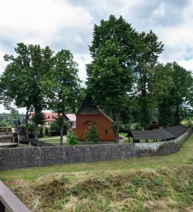 Zdjęcie nr 22: Kościół jednonawowy,  prezbiterium oddzielone ścianą tęczową z poprzeczną belką. Stropy pokryte dekoracją malarską imitującą kasetony z rozetami, z przedstawieniem Matki Boskiej z Dzieciątkiem w prezbiterium, św. Michała Archanioła w nawie oraz klęczących aniołów na ścianach. W dolnej partii ściany niebieskie, z biegnącą dookoła inskrypcją, a do jednej trzeciej wysokości od dołu w kolorze drewna. W przedsionku polichromia patronowa o motywach geometrycznych, roślinnych, zwierzęcych itd.  W nawie od zachodu chór muzyczny z dekoracją malarską roślinną i antropomorficzną. Nawa i prezbiterium naryte pozornym sklepieniem w kształcie spłaszczonej kolebki ze skośnymi fasetami. W nawie głównej jedno duże okno w kształcie stojącego prostokąta, bliżej chóru drugie, niewielkie, w kształcie leżącego; kolejne w wieży, przedsionku i prezbiterium. Główne wejście od zachodu, drugie przez kruchtę od południa, trzecie do zakrystii. Portal południowy prostokątny, osłonięty daszkiem, poniżej trójkątnego szczytu wypełnionego oknem. Od zachodu kwadratowa wieża o pochyłych ścianach pobitych gontem, z nadwieszoną, nieco występującą izbicą szalowaną pionowymi deskami, na dolnych końcach ozdobnie wycinanymi. Ściany obłożone gontem, gładkie. Nad nawą i prezbiterium dach jednokalenicowy, gontowy, wieża z ostrosłupowym hełmem. Nad nawą barokowa wieżyczka na sygnaturkę kryta blachą. 
Najcenniejszym elementem wyposażenia jest gotyckie retabulum ołtarzowe pełniące od 1935 roku rolę ołtarza głównego w miejsce rozebranego, barokowego. Oprócz niego szczególne znaczenie mają fragmenty zachowanej polichromii patronowej z około 1500 roku. 
