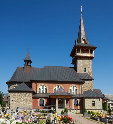 Zdjęcie nr 8: Kościół orientowany, trójnawowy, z niższym i węższym prezbiterium zakończonym absydą. Przy prezbiterium od strony południowej dostawiona kaplica na rzucie prostokąta, od północny analogiczna zakrystia, oba pomieszczenia nakryte dachami czterospadowymi. Do nawy od południa, na wysokości drugiego przęsła dostawiona zadaszona kruchta  wsparta na dwóch kamiennych filarach. Do elewacji zachodniej od południa i północy dostawione dwa aneksy na rzucie prostokąta nakryte dachami czterospadowymi. Nawa główna trójprzęsłowa, znacznie wyższa i szersza od naw bocznych, kryta stropem wspartym na murowanych z cegieł filarach o kompozytowych kapitelach. Doświetlona prostokątnymi oknami zamkniętymi łukiem półkolistym o podziale naśladującym triforium. Nawy boczne wydzielone od głównej półkolistymi arkadami, doświetlone okami w kształcie stojącego prostokąta zamkniętego półkoliście. Prezbiterium kryte prostym stropem oddzielone od nawy ścianą tęczową z półkolistą arkadą z profilowaną archiwoltą. Doświetlone wąskimi oknami w kształcie stojącego prostokąta zamkniętego łukiem półkolistym. Analogiczne okna w kaplicy południowej. W fasadzie czworoboczna zwężająca się ku górze wieża z drewnianą hurdycją, nakryta ostrosłupowym dachem zwieńczonym krzyżem. W przyziemiu portal nakryty wspartym na dwóch kamiennych filarach dachem półszczytowym. Powyżej prosty, drewniany krzyż oraz okrągła płycina mieszcząca tarczę zegarową. Elewacje licowane kamieniem, od południa i północy murowane z czerwonej cegły z kamiennymi obramieniami wokół okien. Dachy kryte blachą, ponad prezbiterium czworoboczna wieżyczka na sygnaturkę zwieńczona ostrosłupowym hełmem.