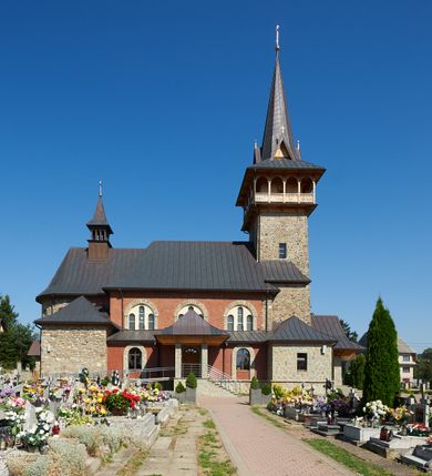 Zdjęcie nr 7: Kościół orientowany, trójnawowy, z niższym i węższym prezbiterium zakończonym absydą. Przy prezbiterium od strony południowej dostawiona kaplica na rzucie prostokąta, od północny analogiczna zakrystia, oba pomieszczenia nakryte dachami czterospadowymi. Do nawy od południa, na wysokości drugiego przęsła dostawiona zadaszona kruchta  wsparta na dwóch kamiennych filarach. Do elewacji zachodniej od południa i północy dostawione dwa aneksy na rzucie prostokąta nakryte dachami czterospadowymi. Nawa główna trójprzęsłowa, znacznie wyższa i szersza od naw bocznych, kryta stropem wspartym na murowanych z cegieł filarach o kompozytowych kapitelach. Doświetlona prostokątnymi oknami zamkniętymi łukiem półkolistym o podziale naśladującym triforium. Nawy boczne wydzielone od głównej półkolistymi arkadami, doświetlone okami w kształcie stojącego prostokąta zamkniętego półkoliście. Prezbiterium kryte prostym stropem oddzielone od nawy ścianą tęczową z półkolistą arkadą z profilowaną archiwoltą. Doświetlone wąskimi oknami w kształcie stojącego prostokąta zamkniętego łukiem półkolistym. Analogiczne okna w kaplicy południowej. W fasadzie czworoboczna zwężająca się ku górze wieża z drewnianą hurdycją, nakryta ostrosłupowym dachem zwieńczonym krzyżem. W przyziemiu portal nakryty wspartym na dwóch kamiennych filarach dachem półszczytowym. Powyżej prosty, drewniany krzyż oraz okrągła płycina mieszcząca tarczę zegarową. Elewacje licowane kamieniem, od południa i północy murowane z czerwonej cegły z kamiennymi obramieniami wokół okien. Dachy kryte blachą, ponad prezbiterium czworoboczna wieżyczka na sygnaturkę zwieńczona ostrosłupowym hełmem.