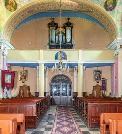 Zdjęcie nr 49: Kościół położony w centrum wsi Pleszów, obecnie w dzielnicy Nowa-Huta, na placu wyznaczonym wysokim, wykonanym z cegły murem, w otoczeniu starodrzewia. Budynek założony na rzucie prostokąta z węższym prostokątnym prezbiterium ujętym z trzech stron piętrowymi aneksami zakrystii, skarbczyka i przedsionka. Nawa jest trójprzęsłowa, ma ścięte naroża, jest artykułowana szerokimi przyściennymi filarami, zaś jednoprzęsłowe prezbiterium ujmują w narożach kolumny. Pilastry i kolumny o jońskich kapitelach dźwigają belkowanie z fryzem z metopami opatrzonymi rozetami na przemian z tryglifami. Nawę i prezbiterium nakrywają żaglaste sklepienia na szerokich gurtach i arkadach nad ścianami bocznymi, w których umieszczono prostokątne okna zamknięte łukiem odcinkowym. Aneksy są skomunikowane z prezbiterium prostokątnymi przejściami. Do kościoła prowadzą od frontu prostokątne drzwi i wbudowana pod chórem muzycznym drewniana kruchtę. 
Fasada jest szersza od korpusu nawy, jednokondygnacyjna, trójosiowa, zwieńczona wysoką wieżą. Korpus fasady ujęty załamującymi się na narożach toskańskimi pilastrami, z częścią środkową wysuniętą do przodu z takimi samymi pilastrami jak na narożach. Pilastry podtrzymują opasujące korpus fasady belkowanie, którego fryz złożony jest z tryglifów i metop wypełnionych kołami; nad częścią środkową trójkątny przyczółek wypełniony okiem Opatrzności. Fasadę wieńczy wysoka attyka ujęta na narożach i w części środkowej postumentami z wazonami. Wieża opasana na narożach szerokimi lizenami podtrzymującymi belkowanie z fryzem konsolkowym jest zakończona czterospadowym, lekko wklęsłym dachem krytym blachą z kulą i krzyżem. Elewacje boczne w korpusie fasady i aneksów przy prezbiterium z dwoma rzędami prostokątnych okienek, w partii nawy i prezbiterium z oknami prostokątnymi zakończonymi łukiem odcinkowym w profilowanych obramieniach. Elewacje boczne wieńczy profilowany gzyms, ściany wysuniętych poza korpus nawy aneksów załamujące się narożach szerokie lizeny. Dach jest dwuspadowy, kryty blachą.     
