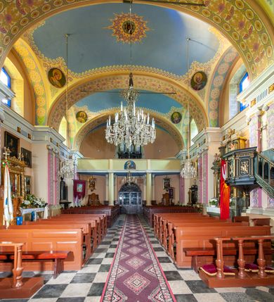 Zdjęcie nr 45: Kościół położony w centrum wsi Pleszów, obecnie w dzielnicy Nowa-Huta, na placu wyznaczonym wysokim, wykonanym z cegły murem, w otoczeniu starodrzewia. Budynek założony na rzucie prostokąta z węższym prostokątnym prezbiterium ujętym z trzech stron piętrowymi aneksami zakrystii, skarbczyka i przedsionka. Nawa jest trójprzęsłowa, ma ścięte naroża, jest artykułowana szerokimi przyściennymi filarami, zaś jednoprzęsłowe prezbiterium ujmują w narożach kolumny. Pilastry i kolumny o jońskich kapitelach dźwigają belkowanie z fryzem z metopami opatrzonymi rozetami na przemian z tryglifami. Nawę i prezbiterium nakrywają żaglaste sklepienia na szerokich gurtach i arkadach nad ścianami bocznymi, w których umieszczono prostokątne okna zamknięte łukiem odcinkowym. Aneksy są skomunikowane z prezbiterium prostokątnymi przejściami. Do kościoła prowadzą od frontu prostokątne drzwi i wbudowana pod chórem muzycznym drewniana kruchtę. 
Fasada jest szersza od korpusu nawy, jednokondygnacyjna, trójosiowa, zwieńczona wysoką wieżą. Korpus fasady ujęty załamującymi się na narożach toskańskimi pilastrami, z częścią środkową wysuniętą do przodu z takimi samymi pilastrami jak na narożach. Pilastry podtrzymują opasujące korpus fasady belkowanie, którego fryz złożony jest z tryglifów i metop wypełnionych kołami; nad częścią środkową trójkątny przyczółek wypełniony okiem Opatrzności. Fasadę wieńczy wysoka attyka ujęta na narożach i w części środkowej postumentami z wazonami. Wieża opasana na narożach szerokimi lizenami podtrzymującymi belkowanie z fryzem konsolkowym jest zakończona czterospadowym, lekko wklęsłym dachem krytym blachą z kulą i krzyżem. Elewacje boczne w korpusie fasady i aneksów przy prezbiterium z dwoma rzędami prostokątnych okienek, w partii nawy i prezbiterium z oknami prostokątnymi zakończonymi łukiem odcinkowym w profilowanych obramieniach. Elewacje boczne wieńczy profilowany gzyms, ściany wysuniętych poza korpus nawy aneksów załamujące się narożach szerokie lizeny. Dach jest dwuspadowy, kryty blachą.     
