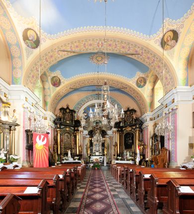 Zdjęcie nr 43: Kościół położony w centrum wsi Pleszów, obecnie w dzielnicy Nowa-Huta, na placu wyznaczonym wysokim, wykonanym z cegły murem, w otoczeniu starodrzewia. Budynek założony na rzucie prostokąta z węższym prostokątnym prezbiterium ujętym z trzech stron piętrowymi aneksami zakrystii, skarbczyka i przedsionka. Nawa jest trójprzęsłowa, ma ścięte naroża, jest artykułowana szerokimi przyściennymi filarami, zaś jednoprzęsłowe prezbiterium ujmują w narożach kolumny. Pilastry i kolumny o jońskich kapitelach dźwigają belkowanie z fryzem z metopami opatrzonymi rozetami na przemian z tryglifami. Nawę i prezbiterium nakrywają żaglaste sklepienia na szerokich gurtach i arkadach nad ścianami bocznymi, w których umieszczono prostokątne okna zamknięte łukiem odcinkowym. Aneksy są skomunikowane z prezbiterium prostokątnymi przejściami. Do kościoła prowadzą od frontu prostokątne drzwi i wbudowana pod chórem muzycznym drewniana kruchtę. 
Fasada jest szersza od korpusu nawy, jednokondygnacyjna, trójosiowa, zwieńczona wysoką wieżą. Korpus fasady ujęty załamującymi się na narożach toskańskimi pilastrami, z częścią środkową wysuniętą do przodu z takimi samymi pilastrami jak na narożach. Pilastry podtrzymują opasujące korpus fasady belkowanie, którego fryz złożony jest z tryglifów i metop wypełnionych kołami; nad częścią środkową trójkątny przyczółek wypełniony okiem Opatrzności. Fasadę wieńczy wysoka attyka ujęta na narożach i w części środkowej postumentami z wazonami. Wieża opasana na narożach szerokimi lizenami podtrzymującymi belkowanie z fryzem konsolkowym jest zakończona czterospadowym, lekko wklęsłym dachem krytym blachą z kulą i krzyżem. Elewacje boczne w korpusie fasady i aneksów przy prezbiterium z dwoma rzędami prostokątnych okienek, w partii nawy i prezbiterium z oknami prostokątnymi zakończonymi łukiem odcinkowym w profilowanych obramieniach. Elewacje boczne wieńczy profilowany gzyms, ściany wysuniętych poza korpus nawy aneksów załamujące się narożach szerokie lizeny. Dach jest dwuspadowy, kryty blachą.     
