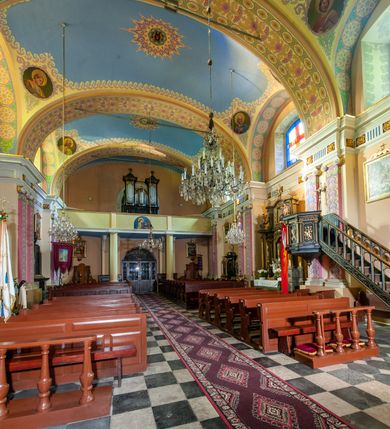 Zdjęcie nr 47: Kościół położony w centrum wsi Pleszów, obecnie w dzielnicy Nowa-Huta, na placu wyznaczonym wysokim, wykonanym z cegły murem, w otoczeniu starodrzewia. Budynek założony na rzucie prostokąta z węższym prostokątnym prezbiterium ujętym z trzech stron piętrowymi aneksami zakrystii, skarbczyka i przedsionka. Nawa jest trójprzęsłowa, ma ścięte naroża, jest artykułowana szerokimi przyściennymi filarami, zaś jednoprzęsłowe prezbiterium ujmują w narożach kolumny. Pilastry i kolumny o jońskich kapitelach dźwigają belkowanie z fryzem z metopami opatrzonymi rozetami na przemian z tryglifami. Nawę i prezbiterium nakrywają żaglaste sklepienia na szerokich gurtach i arkadach nad ścianami bocznymi, w których umieszczono prostokątne okna zamknięte łukiem odcinkowym. Aneksy są skomunikowane z prezbiterium prostokątnymi przejściami. Do kościoła prowadzą od frontu prostokątne drzwi i wbudowana pod chórem muzycznym drewniana kruchtę. 
Fasada jest szersza od korpusu nawy, jednokondygnacyjna, trójosiowa, zwieńczona wysoką wieżą. Korpus fasady ujęty załamującymi się na narożach toskańskimi pilastrami, z częścią środkową wysuniętą do przodu z takimi samymi pilastrami jak na narożach. Pilastry podtrzymują opasujące korpus fasady belkowanie, którego fryz złożony jest z tryglifów i metop wypełnionych kołami; nad częścią środkową trójkątny przyczółek wypełniony okiem Opatrzności. Fasadę wieńczy wysoka attyka ujęta na narożach i w części środkowej postumentami z wazonami. Wieża opasana na narożach szerokimi lizenami podtrzymującymi belkowanie z fryzem konsolkowym jest zakończona czterospadowym, lekko wklęsłym dachem krytym blachą z kulą i krzyżem. Elewacje boczne w korpusie fasady i aneksów przy prezbiterium z dwoma rzędami prostokątnych okienek, w partii nawy i prezbiterium z oknami prostokątnymi zakończonymi łukiem odcinkowym w profilowanych obramieniach. Elewacje boczne wieńczy profilowany gzyms, ściany wysuniętych poza korpus nawy aneksów załamujące się narożach szerokie lizeny. Dach jest dwuspadowy, kryty blachą.     
