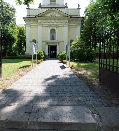 Zdjęcie nr 2: Kościół położony w centrum wsi Pleszów, obecnie w dzielnicy Nowa-Huta, na placu wyznaczonym wysokim, wykonanym z cegły murem, w otoczeniu starodrzewia. Budynek założony na rzucie prostokąta z węższym prostokątnym prezbiterium ujętym z trzech stron piętrowymi aneksami zakrystii, skarbczyka i przedsionka. Nawa jest trójprzęsłowa, ma ścięte naroża, jest artykułowana szerokimi przyściennymi filarami, zaś jednoprzęsłowe prezbiterium ujmują w narożach kolumny. Pilastry i kolumny o jońskich kapitelach dźwigają belkowanie z fryzem z metopami opatrzonymi rozetami na przemian z tryglifami. Nawę i prezbiterium nakrywają żaglaste sklepienia na szerokich gurtach i arkadach nad ścianami bocznymi, w których umieszczono prostokątne okna zamknięte łukiem odcinkowym. Aneksy są skomunikowane z prezbiterium prostokątnymi przejściami. Do kościoła prowadzą od frontu prostokątne drzwi i wbudowana pod chórem muzycznym drewniana kruchtę. 
Fasada jest szersza od korpusu nawy, jednokondygnacyjna, trójosiowa, zwieńczona wysoką wieżą. Korpus fasady ujęty załamującymi się na narożach toskańskimi pilastrami, z częścią środkową wysuniętą do przodu z takimi samymi pilastrami jak na narożach. Pilastry podtrzymują opasujące korpus fasady belkowanie, którego fryz złożony jest z tryglifów i metop wypełnionych kołami; nad częścią środkową trójkątny przyczółek wypełniony okiem Opatrzności. Fasadę wieńczy wysoka attyka ujęta na narożach i w części środkowej postumentami z wazonami. Wieża opasana na narożach szerokimi lizenami podtrzymującymi belkowanie z fryzem konsolkowym jest zakończona czterospadowym, lekko wklęsłym dachem krytym blachą z kulą i krzyżem. Elewacje boczne w korpusie fasady i aneksów przy prezbiterium z dwoma rzędami prostokątnych okienek, w partii nawy i prezbiterium z oknami prostokątnymi zakończonymi łukiem odcinkowym w profilowanych obramieniach. Elewacje boczne wieńczy profilowany gzyms, ściany wysuniętych poza korpus nawy aneksów załamujące się narożach szerokie lizeny. Dach jest dwuspadowy, kryty blachą.     
