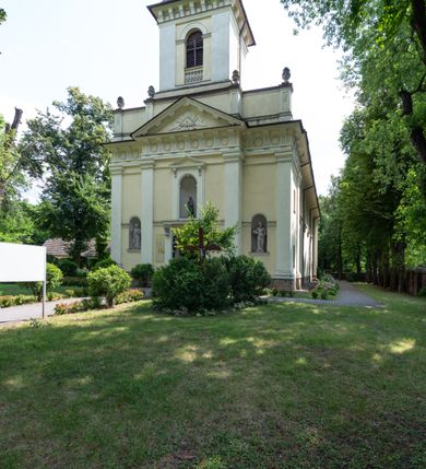 Zdjęcie nr 3: Kościół położony w centrum wsi Pleszów, obecnie w dzielnicy Nowa-Huta, na placu wyznaczonym wysokim, wykonanym z cegły murem, w otoczeniu starodrzewia. Budynek założony na rzucie prostokąta z węższym prostokątnym prezbiterium ujętym z trzech stron piętrowymi aneksami zakrystii, skarbczyka i przedsionka. Nawa jest trójprzęsłowa, ma ścięte naroża, jest artykułowana szerokimi przyściennymi filarami, zaś jednoprzęsłowe prezbiterium ujmują w narożach kolumny. Pilastry i kolumny o jońskich kapitelach dźwigają belkowanie z fryzem z metopami opatrzonymi rozetami na przemian z tryglifami. Nawę i prezbiterium nakrywają żaglaste sklepienia na szerokich gurtach i arkadach nad ścianami bocznymi, w których umieszczono prostokątne okna zamknięte łukiem odcinkowym. Aneksy są skomunikowane z prezbiterium prostokątnymi przejściami. Do kościoła prowadzą od frontu prostokątne drzwi i wbudowana pod chórem muzycznym drewniana kruchtę. 
Fasada jest szersza od korpusu nawy, jednokondygnacyjna, trójosiowa, zwieńczona wysoką wieżą. Korpus fasady ujęty załamującymi się na narożach toskańskimi pilastrami, z częścią środkową wysuniętą do przodu z takimi samymi pilastrami jak na narożach. Pilastry podtrzymują opasujące korpus fasady belkowanie, którego fryz złożony jest z tryglifów i metop wypełnionych kołami; nad częścią środkową trójkątny przyczółek wypełniony okiem Opatrzności. Fasadę wieńczy wysoka attyka ujęta na narożach i w części środkowej postumentami z wazonami. Wieża opasana na narożach szerokimi lizenami podtrzymującymi belkowanie z fryzem konsolkowym jest zakończona czterospadowym, lekko wklęsłym dachem krytym blachą z kulą i krzyżem. Elewacje boczne w korpusie fasady i aneksów przy prezbiterium z dwoma rzędami prostokątnych okienek, w partii nawy i prezbiterium z oknami prostokątnymi zakończonymi łukiem odcinkowym w profilowanych obramieniach. Elewacje boczne wieńczy profilowany gzyms, ściany wysuniętych poza korpus nawy aneksów załamujące się narożach szerokie lizeny. Dach jest dwuspadowy, kryty blachą.     
