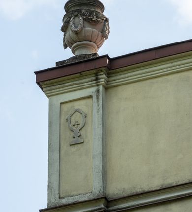 Zdjęcie nr 27: Kościół położony w centrum wsi Pleszów, obecnie w dzielnicy Nowa-Huta, na placu wyznaczonym wysokim, wykonanym z cegły murem, w otoczeniu starodrzewia. Budynek założony na rzucie prostokąta z węższym prostokątnym prezbiterium ujętym z trzech stron piętrowymi aneksami zakrystii, skarbczyka i przedsionka. Nawa jest trójprzęsłowa, ma ścięte naroża, jest artykułowana szerokimi przyściennymi filarami, zaś jednoprzęsłowe prezbiterium ujmują w narożach kolumny. Pilastry i kolumny o jońskich kapitelach dźwigają belkowanie z fryzem z metopami opatrzonymi rozetami na przemian z tryglifami. Nawę i prezbiterium nakrywają żaglaste sklepienia na szerokich gurtach i arkadach nad ścianami bocznymi, w których umieszczono prostokątne okna zamknięte łukiem odcinkowym. Aneksy są skomunikowane z prezbiterium prostokątnymi przejściami. Do kościoła prowadzą od frontu prostokątne drzwi i wbudowana pod chórem muzycznym drewniana kruchtę. 
Fasada jest szersza od korpusu nawy, jednokondygnacyjna, trójosiowa, zwieńczona wysoką wieżą. Korpus fasady ujęty załamującymi się na narożach toskańskimi pilastrami, z częścią środkową wysuniętą do przodu z takimi samymi pilastrami jak na narożach. Pilastry podtrzymują opasujące korpus fasady belkowanie, którego fryz złożony jest z tryglifów i metop wypełnionych kołami; nad częścią środkową trójkątny przyczółek wypełniony okiem Opatrzności. Fasadę wieńczy wysoka attyka ujęta na narożach i w części środkowej postumentami z wazonami. Wieża opasana na narożach szerokimi lizenami podtrzymującymi belkowanie z fryzem konsolkowym jest zakończona czterospadowym, lekko wklęsłym dachem krytym blachą z kulą i krzyżem. Elewacje boczne w korpusie fasady i aneksów przy prezbiterium z dwoma rzędami prostokątnych okienek, w partii nawy i prezbiterium z oknami prostokątnymi zakończonymi łukiem odcinkowym w profilowanych obramieniach. Elewacje boczne wieńczy profilowany gzyms, ściany wysuniętych poza korpus nawy aneksów załamujące się narożach szerokie lizeny. Dach jest dwuspadowy, kryty blachą.     
