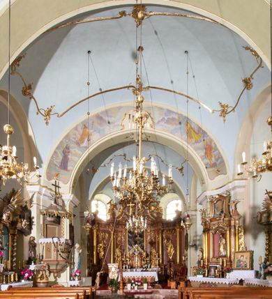 Zdjęcie nr 18: Kościół orientowany, murowany, tynkowany, jednonawowy, z prostokątną, trójprzęsłową nawą oraz węższym jednoprzęsłowym prezbiterium zamkniętym półkoliście, z dużą, prostokątną zakrystią przy północnej ścianie. Od zachodu wieża na planie kwadratu, do południowej ściany nawy dobudowana niewielka kruchta na planie kwadratu. 
Prezbiterium i nawa nakryte sklepieniem żagielkowym na gurtach spływających na pilastry. Otwór tęczowy w formie  arkady. W zachodniej części nawy parapet chóru muzycznego, o wklęsło-wypukłej balustradzie, wsparty na dwóch filarach i dwóch półfilarach, tworząc trzy arkady. Posadzka kamienna. 
Fasada wieżowa, z wejściem na osi w postaci drewnianego portyku nakrytego blaszanym daszkiem dwuspadowym. Wieża smukła, bez podziałów architektonicznych, zakończona dwoma profilowanymi gzymsami, wyłamującymi się na każdej ścianie na kształt łuku odcinkowego. Pomiędzy nimi, na ścianie frontowej tarcza zegarowa. W połowie wysokości wieży, z trzech stron niewielkie okna w formie stojącego prostokąta w okrągłych płycinach. W najwyższej partii ścian, z czterech stron, otwory dzwonne w formie stojącego prostokąta zamkniętego łukiem półkolistym. Wieża zwieńczona hełmem baniastym z latarnią, zakończoną kulą z krzyżem, pokrytym blachą. Elewacje bez podziałów, zakończone profilowanym gzymsem. W południowej cztery otwory okienne w formie stojącego prostokąta zamkniętego łukiem półkolistym, we wschodniej dwa analogiczne, w północnej jedno. 
Nawa i prezbiterium nakryte dachem dwuspadowym, blaszanym. W miejscu połączenia prezbiterium i nawy blaszana wieżyczka na sygnaturkę, z latarnią, zwieńczona hełmem baniastym z krzyżem. Zakrystia nakryta dachem trójspadowym, kruchta dachem falistym. Kościół otoczony niskim murem kamiennym.
