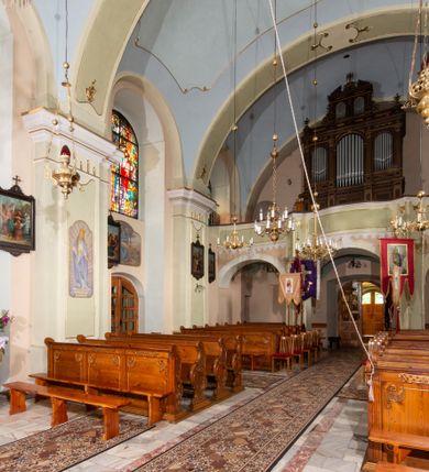 Zdjęcie nr 22: Kościół orientowany, murowany, tynkowany, jednonawowy, z prostokątną, trójprzęsłową nawą oraz węższym jednoprzęsłowym prezbiterium zamkniętym półkoliście, z dużą, prostokątną zakrystią przy północnej ścianie. Od zachodu wieża na planie kwadratu, do południowej ściany nawy dobudowana niewielka kruchta na planie kwadratu. 
Prezbiterium i nawa nakryte sklepieniem żagielkowym na gurtach spływających na pilastry. Otwór tęczowy w formie  arkady. W zachodniej części nawy parapet chóru muzycznego, o wklęsło-wypukłej balustradzie, wsparty na dwóch filarach i dwóch półfilarach, tworząc trzy arkady. Posadzka kamienna. 
Fasada wieżowa, z wejściem na osi w postaci drewnianego portyku nakrytego blaszanym daszkiem dwuspadowym. Wieża smukła, bez podziałów architektonicznych, zakończona dwoma profilowanymi gzymsami, wyłamującymi się na każdej ścianie na kształt łuku odcinkowego. Pomiędzy nimi, na ścianie frontowej tarcza zegarowa. W połowie wysokości wieży, z trzech stron niewielkie okna w formie stojącego prostokąta w okrągłych płycinach. W najwyższej partii ścian, z czterech stron, otwory dzwonne w formie stojącego prostokąta zamkniętego łukiem półkolistym. Wieża zwieńczona hełmem baniastym z latarnią, zakończoną kulą z krzyżem, pokrytym blachą. Elewacje bez podziałów, zakończone profilowanym gzymsem. W południowej cztery otwory okienne w formie stojącego prostokąta zamkniętego łukiem półkolistym, we wschodniej dwa analogiczne, w północnej jedno. 
Nawa i prezbiterium nakryte dachem dwuspadowym, blaszanym. W miejscu połączenia prezbiterium i nawy blaszana wieżyczka na sygnaturkę, z latarnią, zwieńczona hełmem baniastym z krzyżem. Zakrystia nakryta dachem trójspadowym, kruchta dachem falistym. Kościół otoczony niskim murem kamiennym.
