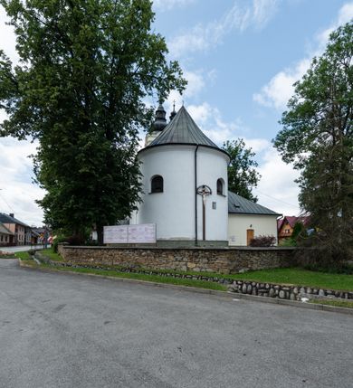Zdjęcie nr 7: Kościół orientowany, murowany, tynkowany, jednonawowy, z prostokątną, trójprzęsłową nawą oraz węższym jednoprzęsłowym prezbiterium zamkniętym półkoliście, z dużą, prostokątną zakrystią przy północnej ścianie. Od zachodu wieża na planie kwadratu, do południowej ściany nawy dobudowana niewielka kruchta na planie kwadratu. 
Prezbiterium i nawa nakryte sklepieniem żagielkowym na gurtach spływających na pilastry. Otwór tęczowy w formie  arkady. W zachodniej części nawy parapet chóru muzycznego, o wklęsło-wypukłej balustradzie, wsparty na dwóch filarach i dwóch półfilarach, tworząc trzy arkady. Posadzka kamienna. 
Fasada wieżowa, z wejściem na osi w postaci drewnianego portyku nakrytego blaszanym daszkiem dwuspadowym. Wieża smukła, bez podziałów architektonicznych, zakończona dwoma profilowanymi gzymsami, wyłamującymi się na każdej ścianie na kształt łuku odcinkowego. Pomiędzy nimi, na ścianie frontowej tarcza zegarowa. W połowie wysokości wieży, z trzech stron niewielkie okna w formie stojącego prostokąta w okrągłych płycinach. W najwyższej partii ścian, z czterech stron, otwory dzwonne w formie stojącego prostokąta zamkniętego łukiem półkolistym. Wieża zwieńczona hełmem baniastym z latarnią, zakończoną kulą z krzyżem, pokrytym blachą. Elewacje bez podziałów, zakończone profilowanym gzymsem. W południowej cztery otwory okienne w formie stojącego prostokąta zamkniętego łukiem półkolistym, we wschodniej dwa analogiczne, w północnej jedno. 
Nawa i prezbiterium nakryte dachem dwuspadowym, blaszanym. W miejscu połączenia prezbiterium i nawy blaszana wieżyczka na sygnaturkę, z latarnią, zwieńczona hełmem baniastym z krzyżem. Zakrystia nakryta dachem trójspadowym, kruchta dachem falistym. Kościół otoczony niskim murem kamiennym.
