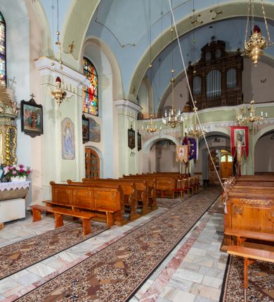 Zdjęcie nr 24: Kościół orientowany, murowany, tynkowany, jednonawowy, z prostokątną, trójprzęsłową nawą oraz węższym jednoprzęsłowym prezbiterium zamkniętym półkoliście, z dużą, prostokątną zakrystią przy północnej ścianie. Od zachodu wieża na planie kwadratu, do południowej ściany nawy dobudowana niewielka kruchta na planie kwadratu. 
Prezbiterium i nawa nakryte sklepieniem żagielkowym na gurtach spływających na pilastry. Otwór tęczowy w formie  arkady. W zachodniej części nawy parapet chóru muzycznego, o wklęsło-wypukłej balustradzie, wsparty na dwóch filarach i dwóch półfilarach, tworząc trzy arkady. Posadzka kamienna. 
Fasada wieżowa, z wejściem na osi w postaci drewnianego portyku nakrytego blaszanym daszkiem dwuspadowym. Wieża smukła, bez podziałów architektonicznych, zakończona dwoma profilowanymi gzymsami, wyłamującymi się na każdej ścianie na kształt łuku odcinkowego. Pomiędzy nimi, na ścianie frontowej tarcza zegarowa. W połowie wysokości wieży, z trzech stron niewielkie okna w formie stojącego prostokąta w okrągłych płycinach. W najwyższej partii ścian, z czterech stron, otwory dzwonne w formie stojącego prostokąta zamkniętego łukiem półkolistym. Wieża zwieńczona hełmem baniastym z latarnią, zakończoną kulą z krzyżem, pokrytym blachą. Elewacje bez podziałów, zakończone profilowanym gzymsem. W południowej cztery otwory okienne w formie stojącego prostokąta zamkniętego łukiem półkolistym, we wschodniej dwa analogiczne, w północnej jedno. 
Nawa i prezbiterium nakryte dachem dwuspadowym, blaszanym. W miejscu połączenia prezbiterium i nawy blaszana wieżyczka na sygnaturkę, z latarnią, zwieńczona hełmem baniastym z krzyżem. Zakrystia nakryta dachem trójspadowym, kruchta dachem falistym. Kościół otoczony niskim murem kamiennym.
