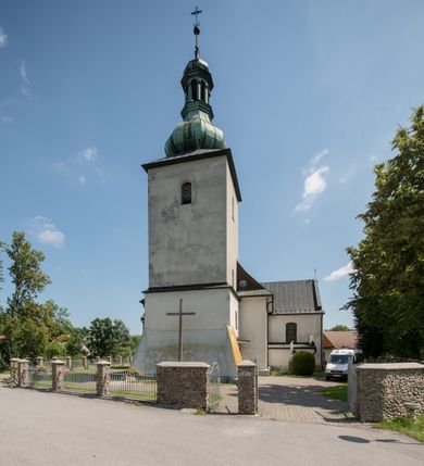Zdjęcie nr 2: Kościół orientowany, murowany, jednonawowy, z prezbiterium, z zakrystią od północy i nawą z dwiema kaplicami – jedną od południa i drugą od północy. Od południa przylega do niego kruchta, a od zachodu wieża. Prezbiterium jest węższe od nawy, zamknięte wielobocznie, oddziela je tęcza o łuku półkolistym wsparta na pilastrach. Od zachodu chór na dwóch filarach, zamknięty balustradą wysuniętą przed lico w części środkowej i dekorowaną płycinami z umieszczonymi symetrycznie krzyżami łacińskimi. Ściany wnętrza gładkie, brak podziałów pionowych, partię ścian od sklepienia oddziela niebieski gzyms. Dół ścian wyłożony drewnianą boazerią, w prezbiterium kamiennymi płytami. Ściany przeprute oknami – prezbiterium czterema, nawa sześcioma w kształcie stojącego prostokąta zamkniętego łukiem odcinkowym, kolejne w kaplicach; większość wypełniają witraże. Główne wejście przez korpus wieżowy od zachodu, drugie od zakrystii. Elewacje kościoła są gładkie, narożniki podkreślone lizenami, wieża o dwóch kondygnacjach przedzielonych kapnikiem. W pierwszej wejście poniżej okna, od zachodu przypora, w drugiej cztery niewielkie okna. Dach jednokalenicowy, wieżyczka na sygnaturkę o kształcie barokowym, wieża przekryta hełmem baniastym z latarnią. Od zewnątrz, na wschodniej ścianie prezbiterium ogrójec w formie drewnianej altany. Do najstarszych elementów wyposażenia należą ołtarz główny z końca XVII wieku z wizerunkiem Matki Boskiej z Dzieciątkiem oraz osiemnastowieczne ołtarze boczne ustawione w nawie głównej. 