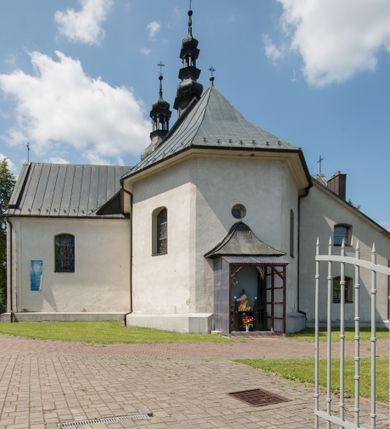 Zdjęcie nr 3: Kościół orientowany, murowany, jednonawowy, z prezbiterium, z zakrystią od północy i nawą z dwiema kaplicami – jedną od południa i drugą od północy. Od południa przylega do niego kruchta, a od zachodu wieża. Prezbiterium jest węższe od nawy, zamknięte wielobocznie, oddziela je tęcza o łuku półkolistym wsparta na pilastrach. Od zachodu chór na dwóch filarach, zamknięty balustradą wysuniętą przed lico w części środkowej i dekorowaną płycinami z umieszczonymi symetrycznie krzyżami łacińskimi. Ściany wnętrza gładkie, brak podziałów pionowych, partię ścian od sklepienia oddziela niebieski gzyms. Dół ścian wyłożony drewnianą boazerią, w prezbiterium kamiennymi płytami. Ściany przeprute oknami – prezbiterium czterema, nawa sześcioma w kształcie stojącego prostokąta zamkniętego łukiem odcinkowym, kolejne w kaplicach; większość wypełniają witraże. Główne wejście przez korpus wieżowy od zachodu, drugie od zakrystii. Elewacje kościoła są gładkie, narożniki podkreślone lizenami, wieża o dwóch kondygnacjach przedzielonych kapnikiem. W pierwszej wejście poniżej okna, od zachodu przypora, w drugiej cztery niewielkie okna. Dach jednokalenicowy, wieżyczka na sygnaturkę o kształcie barokowym, wieża przekryta hełmem baniastym z latarnią. Od zewnątrz, na wschodniej ścianie prezbiterium ogrójec w formie drewnianej altany. Do najstarszych elementów wyposażenia należą ołtarz główny z końca XVII wieku z wizerunkiem Matki Boskiej z Dzieciątkiem oraz osiemnastowieczne ołtarze boczne ustawione w nawie głównej. 