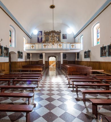 Zdjęcie nr 14: Kościół orientowany, murowany, jednonawowy, z prezbiterium, z zakrystią od północy i nawą z dwiema kaplicami – jedną od południa i drugą od północy. Od południa przylega do niego kruchta, a od zachodu wieża. Prezbiterium jest węższe od nawy, zamknięte wielobocznie, oddziela je tęcza o łuku półkolistym wsparta na pilastrach. Od zachodu chór na dwóch filarach, zamknięty balustradą wysuniętą przed lico w części środkowej i dekorowaną płycinami z umieszczonymi symetrycznie krzyżami łacińskimi. Ściany wnętrza gładkie, brak podziałów pionowych, partię ścian od sklepienia oddziela niebieski gzyms. Dół ścian wyłożony drewnianą boazerią, w prezbiterium kamiennymi płytami. Ściany przeprute oknami – prezbiterium czterema, nawa sześcioma w kształcie stojącego prostokąta zamkniętego łukiem odcinkowym, kolejne w kaplicach; większość wypełniają witraże. Główne wejście przez korpus wieżowy od zachodu, drugie od zakrystii. Elewacje kościoła są gładkie, narożniki podkreślone lizenami, wieża o dwóch kondygnacjach przedzielonych kapnikiem. W pierwszej wejście poniżej okna, od zachodu przypora, w drugiej cztery niewielkie okna. Dach jednokalenicowy, wieżyczka na sygnaturkę o kształcie barokowym, wieża przekryta hełmem baniastym z latarnią. Od zewnątrz, na wschodniej ścianie prezbiterium ogrójec w formie drewnianej altany. Do najstarszych elementów wyposażenia należą ołtarz główny z końca XVII wieku z wizerunkiem Matki Boskiej z Dzieciątkiem oraz osiemnastowieczne ołtarze boczne ustawione w nawie głównej. 