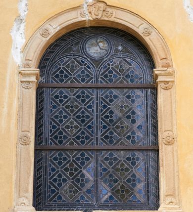 Zdjęcie nr 17: Kościół murowany z cegły i kamienia, tynkowany. Zlokalizowany po północnej stronie wiejskiej drogi, na placu wydzielonym drewnianym płotem rozpiętym pomiędzy murowanymi, tynkowanymi filarami. Budowla orientowana, wzniesiona na wydłużonym rzucie złożonym z krótkiego, zamkniętego wielobocznie prezbiterium, nawy na rzucie zbliżonym  do kwadratu z centralnie umieszczonym filarem i wieży na rzucie kwadratu. Od północy do prezbiterium przylega zakrystia na rzucie kwadratu, do nawy kaplica na rzucie prostokąta. Do wieży dostawiony aneks z klatką schodową prowadzącą na chór. Od południa do nawy przylega kruchta na rzucie kwadratu. Całość budowli oszkarpowana w narożach. Wnętrze nakrywają sklepienia krzyżowe, w nawie żebra wsparte są na czworobocznym, murowanym filarze centralnym. W kruchcie pod wieżą sklepienie kryształowe, w zakrystii sieciowe. Otwory drzwiowe o wykroju ostrołukowym, w kamiennych portalach. Okna o wykroju stojących prostokątów, zwieńczonych łukiem pełnym; w północnej ścianie kaplicy okulus. Elewacje świątyni opracowane jednolicie, tynkowane, z niezbyt wydatnym gzymsem podokapowym, w narożach opięte masywnymi, trójuskokowymi przyporami. Elewacja zachodnia, wieżowa, czterokondygnacyjna, jednoosiowa, flankowana parą przypór. Gzyms kordonowy wydziela ostatnią, najwyższa kondygnację. W osi portal kamienny, zamknięty łukiem półkolistym. Powyżej, w osi okna w każdej z kondygnacji. Na pierwszym piętrze, w zworniku obramienia okiennego herb Drużyna w kartuszu. Boczne elewacje wieży bez otworów okiennych. Elewacja północna artykułowana przyporami, o nieregularnym układzie osi, przesłonięta przybudówkami kaplicy, zakrystii i klatki schodowej wiodącej na chór. W elewacji kaplicy, w osi okulus. W części prezbiterialnej okna o wykroju prostokąta zamkniętego łukiem półkolistym w dekoracyjnych obramieniach kamiennych z pilasterkami i archiwoltą zdobione płycinami i dekoracją ornamentalną w formie rozet i herbem Drużyna. Elewacja wschodnia artykułowana przyporami, przesłonięta parawanową ścianką drewnianą o trzech przeszklonych oknach-arkadah; w głębi ogrójec. Elewacja południowa artykułowana przyporami. W osi korpusu nawowego kruchta, ponad nią, po bokach dwa okna z obramieniami kamiennymi, dekorowanymi ornamentalnie i herbem Drużyna.  Dachy dwuspadowe, kryte blachą. Nieco wyższy nad korpusem nawowym, niższy nad prezbiterium. Nad zakrystią dach pulpitowy. Wieża zwieńczona cebulastym hełmem z latarnią.