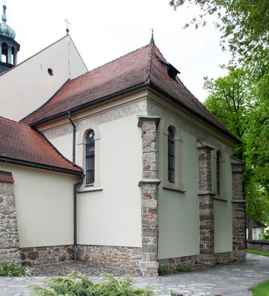 Zdjęcie nr 30: Kościół ceglany, jednonawowy z transeptem. Nawa artykułowana półfilarami i półkolumnami przechodzącymi w gurty sklepienia kolebkowego z lunetami w nawie głównej i żaglowego na przecięciu naw. Na ścianach polichromia na cegle, gurty podkreślone pasami wzorów geometrycznych, sklepienie niebieskie. W nawie i prezbiterium okna w formie biforiów, w transepcie w kształcie stojącego prostokąta zamkniętego łukiem pełnym, z maswerkami, w chórze węższe, zamknięte łukiem ostrym, dwudzielne z rozetą oraz biforia; główne wejście na osi. Chór muzyczny wsparty na masywnych filarach i kolumnach o kapitelach kostkowych z kamiennym parapetem ozdobionym fryzem arkadkowym. Na osi wieloplanowej fasady potężna, trójkondygnacyjna wieża. W pierwszej kondygnacji, po schodach wejście w formie łuku pełnego z drzwiami w formie stojącego prostokąta zamkniętego łukiem dwuramiennym. Obramienie wejścia kamienne, flankowane kolumnami z kostkowymi kapitelami, ze szczytem z chrystogramem. Całość wtopiona w szerszy szczyt, w zwieńczeniu którego rozeta. W trzeciej kondygnacji, zakomponowanej na drugim planie, okno w kształcie stojącego prostokąta zamkniętego łukiem pełnym, dwudzielne z rozetą. Nad nim rzeźba ukrzyżowanego Chrystusa, a w czterech narożach, na konsolach figury św. Stanisława biskupa, św. Stanisława Kostki, św. Jana Kantego i św. Kazimierza Jagiellończyka wykonane z kamienia pińczowskiego przez krakowskiego rzeźbiarza Władysława Druciaka. Wieżę flankują dwie mniejsze, również trójkondygnacyjne wieżyczki dołem czworoboczne, przechodzące w ośmiobok przepruty małymi, prostokątnymi oknami w dwóch niższych kondygnacjach i takimi samymi, naprzemiennie z biforiami w najwyższej. Elewacje transeptu z ogromnymi oknami dekorowanymi maswerkiem, zamknięte trójkątnymi szczytami. Elewacje zewnętrzne z wielobarwnej cegły – w większości ciemnej, dekorowanej na dwóch lub trzech poziomach pasami. Na poziomie pierwszej kondygnacji z jasnej cegły między pasami kamienia, poniżej linii dachu ze wzorem geometrycznym między pasami kamienia, w szczytach jasnym wzorem geometrycznym; chór dekorują blendy arkadkowe. Elewacje opinają ceglane szkarpy, w obejściu zwieńczone kamiennymi kapliczkami. Dachy nawy i transeptu dwuspadowe, dekorowane mozaiką geometryczną, wieloboczna kaplica z dachem sześciokątnym zwieńczonym barokową w kształcie wieżyczką na sygnaturkę, obejście pulpitowym. Do kaplicy przylega przełączka łącząca nowy kościół ze starym.  

Z wyposażenia kościoła na uwagę zasługują obraz Matki Boskiej Suskiej i dwie rzeźby (św. Łukasza i św. Jana Ewangelisty) przeniesione z ołtarza bocznego starego kościoła ustawione na ołtarzu głównym. Sam ołtarz główny (1912) wykonany został przez Antoniego Madeyskiego w Rzymie według rysunków Zygmunta Hendla. Madeyski wykorzystał do wzniesienia ołtarza rzadkie gatunki marmurów z rozebranego starochrześcijańskiego kościoła włoskiego. Niestety przerobiono go i zubożono w 1988 roku. Antoni Madeyski wykonał również tabernakulum, mensę ołtarzową, pulpit oraz chrzcielnicę. Teodor Talowski, architekt, zaprojektował również w 1901 roku ambonę z baldachimem. Zygmunt Hendel zaprojektował, prócz ołtarza głównego, ołtarz boczny św. Józefa i męki Pańskiej (1927). Franciszek Mączyński wykonał figurę Serca Pana Jezusa w latach 1914-1915. Za ołtarzem ze sceną Nawiedzenia widoczne są witraże według kartonów Zdzisława Giedliczki, w prezbiterium ze sceną Zesłania Ducha Świętego i postaciami Matki Boskiej Ostrobramskiej i św. Aleksandra.