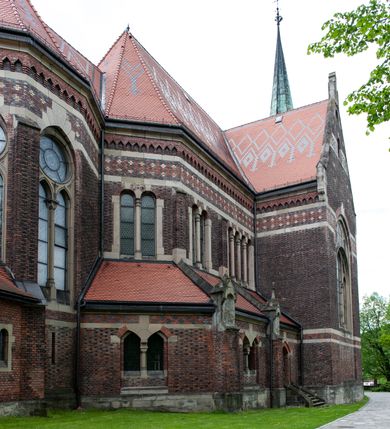 Zdjęcie nr 12: Kościół ceglany, jednonawowy z transeptem. Nawa artykułowana półfilarami i półkolumnami przechodzącymi w gurty sklepienia kolebkowego z lunetami w nawie głównej i żaglowego na przecięciu naw. Na ścianach polichromia na cegle, gurty podkreślone pasami wzorów geometrycznych, sklepienie niebieskie. W nawie i prezbiterium okna w formie biforiów, w transepcie w kształcie stojącego prostokąta zamkniętego łukiem pełnym, z maswerkami, w chórze węższe, zamknięte łukiem ostrym, dwudzielne z rozetą oraz biforia; główne wejście na osi. Chór muzyczny wsparty na masywnych filarach i kolumnach o kapitelach kostkowych z kamiennym parapetem ozdobionym fryzem arkadkowym. Na osi wieloplanowej fasady potężna, trójkondygnacyjna wieża. W pierwszej kondygnacji, po schodach wejście w formie łuku pełnego z drzwiami w formie stojącego prostokąta zamkniętego łukiem dwuramiennym. Obramienie wejścia kamienne, flankowane kolumnami z kostkowymi kapitelami, ze szczytem z chrystogramem. Całość wtopiona w szerszy szczyt, w zwieńczeniu którego rozeta. W trzeciej kondygnacji, zakomponowanej na drugim planie, okno w kształcie stojącego prostokąta zamkniętego łukiem pełnym, dwudzielne z rozetą. Nad nim rzeźba ukrzyżowanego Chrystusa, a w czterech narożach, na konsolach figury św. Stanisława biskupa, św. Stanisława Kostki, św. Jana Kantego i św. Kazimierza Jagiellończyka wykonane z kamienia pińczowskiego przez krakowskiego rzeźbiarza Władysława Druciaka. Wieżę flankują dwie mniejsze, również trójkondygnacyjne wieżyczki dołem czworoboczne, przechodzące w ośmiobok przepruty małymi, prostokątnymi oknami w dwóch niższych kondygnacjach i takimi samymi, naprzemiennie z biforiami w najwyższej. Elewacje transeptu z ogromnymi oknami dekorowanymi maswerkiem, zamknięte trójkątnymi szczytami. Elewacje zewnętrzne z wielobarwnej cegły – w większości ciemnej, dekorowanej na dwóch lub trzech poziomach pasami. Na poziomie pierwszej kondygnacji z jasnej cegły między pasami kamienia, poniżej linii dachu ze wzorem geometrycznym między pasami kamienia, w szczytach jasnym wzorem geometrycznym; chór dekorują blendy arkadkowe. Elewacje opinają ceglane szkarpy, w obejściu zwieńczone kamiennymi kapliczkami. Dachy nawy i transeptu dwuspadowe, dekorowane mozaiką geometryczną, wieloboczna kaplica z dachem sześciokątnym zwieńczonym barokową w kształcie wieżyczką na sygnaturkę, obejście pulpitowym. Do kaplicy przylega przełączka łącząca nowy kościół ze starym.  

Z wyposażenia kościoła na uwagę zasługują obraz Matki Boskiej Suskiej i dwie rzeźby (św. Łukasza i św. Jana Ewangelisty) przeniesione z ołtarza bocznego starego kościoła ustawione na ołtarzu głównym. Sam ołtarz główny (1912) wykonany został przez Antoniego Madeyskiego w Rzymie według rysunków Zygmunta Hendla. Madeyski wykorzystał do wzniesienia ołtarza rzadkie gatunki marmurów z rozebranego starochrześcijańskiego kościoła włoskiego. Niestety przerobiono go i zubożono w 1988 roku. Antoni Madeyski wykonał również tabernakulum, mensę ołtarzową, pulpit oraz chrzcielnicę. Teodor Talowski, architekt, zaprojektował również w 1901 roku ambonę z baldachimem. Zygmunt Hendel zaprojektował, prócz ołtarza głównego, ołtarz boczny św. Józefa i męki Pańskiej (1927). Franciszek Mączyński wykonał figurę Serca Pana Jezusa w latach 1914-1915. Za ołtarzem ze sceną Nawiedzenia widoczne są witraże według kartonów Zdzisława Giedliczki, w prezbiterium ze sceną Zesłania Ducha Świętego i postaciami Matki Boskiej Ostrobramskiej i św. Aleksandra.
