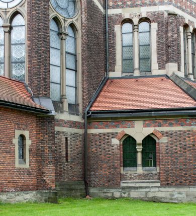 Zdjęcie nr 13: Kościół ceglany, jednonawowy z transeptem. Nawa artykułowana półfilarami i półkolumnami przechodzącymi w gurty sklepienia kolebkowego z lunetami w nawie głównej i żaglowego na przecięciu naw. Na ścianach polichromia na cegle, gurty podkreślone pasami wzorów geometrycznych, sklepienie niebieskie. W nawie i prezbiterium okna w formie biforiów, w transepcie w kształcie stojącego prostokąta zamkniętego łukiem pełnym, z maswerkami, w chórze węższe, zamknięte łukiem ostrym, dwudzielne z rozetą oraz biforia; główne wejście na osi. Chór muzyczny wsparty na masywnych filarach i kolumnach o kapitelach kostkowych z kamiennym parapetem ozdobionym fryzem arkadkowym. Na osi wieloplanowej fasady potężna, trójkondygnacyjna wieża. W pierwszej kondygnacji, po schodach wejście w formie łuku pełnego z drzwiami w formie stojącego prostokąta zamkniętego łukiem dwuramiennym. Obramienie wejścia kamienne, flankowane kolumnami z kostkowymi kapitelami, ze szczytem z chrystogramem. Całość wtopiona w szerszy szczyt, w zwieńczeniu którego rozeta. W trzeciej kondygnacji, zakomponowanej na drugim planie, okno w kształcie stojącego prostokąta zamkniętego łukiem pełnym, dwudzielne z rozetą. Nad nim rzeźba ukrzyżowanego Chrystusa, a w czterech narożach, na konsolach figury św. Stanisława biskupa, św. Stanisława Kostki, św. Jana Kantego i św. Kazimierza Jagiellończyka wykonane z kamienia pińczowskiego przez krakowskiego rzeźbiarza Władysława Druciaka. Wieżę flankują dwie mniejsze, również trójkondygnacyjne wieżyczki dołem czworoboczne, przechodzące w ośmiobok przepruty małymi, prostokątnymi oknami w dwóch niższych kondygnacjach i takimi samymi, naprzemiennie z biforiami w najwyższej. Elewacje transeptu z ogromnymi oknami dekorowanymi maswerkiem, zamknięte trójkątnymi szczytami. Elewacje zewnętrzne z wielobarwnej cegły – w większości ciemnej, dekorowanej na dwóch lub trzech poziomach pasami. Na poziomie pierwszej kondygnacji z jasnej cegły między pasami kamienia, poniżej linii dachu ze wzorem geometrycznym między pasami kamienia, w szczytach jasnym wzorem geometrycznym; chór dekorują blendy arkadkowe. Elewacje opinają ceglane szkarpy, w obejściu zwieńczone kamiennymi kapliczkami. Dachy nawy i transeptu dwuspadowe, dekorowane mozaiką geometryczną, wieloboczna kaplica z dachem sześciokątnym zwieńczonym barokową w kształcie wieżyczką na sygnaturkę, obejście pulpitowym. Do kaplicy przylega przełączka łącząca nowy kościół ze starym.  

Z wyposażenia kościoła na uwagę zasługują obraz Matki Boskiej Suskiej i dwie rzeźby (św. Łukasza i św. Jana Ewangelisty) przeniesione z ołtarza bocznego starego kościoła ustawione na ołtarzu głównym. Sam ołtarz główny (1912) wykonany został przez Antoniego Madeyskiego w Rzymie według rysunków Zygmunta Hendla. Madeyski wykorzystał do wzniesienia ołtarza rzadkie gatunki marmurów z rozebranego starochrześcijańskiego kościoła włoskiego. Niestety przerobiono go i zubożono w 1988 roku. Antoni Madeyski wykonał również tabernakulum, mensę ołtarzową, pulpit oraz chrzcielnicę. Teodor Talowski, architekt, zaprojektował również w 1901 roku ambonę z baldachimem. Zygmunt Hendel zaprojektował, prócz ołtarza głównego, ołtarz boczny św. Józefa i męki Pańskiej (1927). Franciszek Mączyński wykonał figurę Serca Pana Jezusa w latach 1914-1915. Za ołtarzem ze sceną Nawiedzenia widoczne są witraże według kartonów Zdzisława Giedliczki, w prezbiterium ze sceną Zesłania Ducha Świętego i postaciami Matki Boskiej Ostrobramskiej i św. Aleksandra.