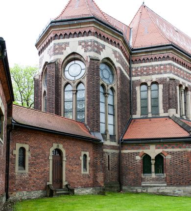 Zdjęcie nr 15: Kościół ceglany, jednonawowy z transeptem. Nawa artykułowana półfilarami i półkolumnami przechodzącymi w gurty sklepienia kolebkowego z lunetami w nawie głównej i żaglowego na przecięciu naw. Na ścianach polichromia na cegle, gurty podkreślone pasami wzorów geometrycznych, sklepienie niebieskie. W nawie i prezbiterium okna w formie biforiów, w transepcie w kształcie stojącego prostokąta zamkniętego łukiem pełnym, z maswerkami, w chórze węższe, zamknięte łukiem ostrym, dwudzielne z rozetą oraz biforia; główne wejście na osi. Chór muzyczny wsparty na masywnych filarach i kolumnach o kapitelach kostkowych z kamiennym parapetem ozdobionym fryzem arkadkowym. Na osi wieloplanowej fasady potężna, trójkondygnacyjna wieża. W pierwszej kondygnacji, po schodach wejście w formie łuku pełnego z drzwiami w formie stojącego prostokąta zamkniętego łukiem dwuramiennym. Obramienie wejścia kamienne, flankowane kolumnami z kostkowymi kapitelami, ze szczytem z chrystogramem. Całość wtopiona w szerszy szczyt, w zwieńczeniu którego rozeta. W trzeciej kondygnacji, zakomponowanej na drugim planie, okno w kształcie stojącego prostokąta zamkniętego łukiem pełnym, dwudzielne z rozetą. Nad nim rzeźba ukrzyżowanego Chrystusa, a w czterech narożach, na konsolach figury św. Stanisława biskupa, św. Stanisława Kostki, św. Jana Kantego i św. Kazimierza Jagiellończyka wykonane z kamienia pińczowskiego przez krakowskiego rzeźbiarza Władysława Druciaka. Wieżę flankują dwie mniejsze, również trójkondygnacyjne wieżyczki dołem czworoboczne, przechodzące w ośmiobok przepruty małymi, prostokątnymi oknami w dwóch niższych kondygnacjach i takimi samymi, naprzemiennie z biforiami w najwyższej. Elewacje transeptu z ogromnymi oknami dekorowanymi maswerkiem, zamknięte trójkątnymi szczytami. Elewacje zewnętrzne z wielobarwnej cegły – w większości ciemnej, dekorowanej na dwóch lub trzech poziomach pasami. Na poziomie pierwszej kondygnacji z jasnej cegły między pasami kamienia, poniżej linii dachu ze wzorem geometrycznym między pasami kamienia, w szczytach jasnym wzorem geometrycznym; chór dekorują blendy arkadkowe. Elewacje opinają ceglane szkarpy, w obejściu zwieńczone kamiennymi kapliczkami. Dachy nawy i transeptu dwuspadowe, dekorowane mozaiką geometryczną, wieloboczna kaplica z dachem sześciokątnym zwieńczonym barokową w kształcie wieżyczką na sygnaturkę, obejście pulpitowym. Do kaplicy przylega przełączka łącząca nowy kościół ze starym.  

Z wyposażenia kościoła na uwagę zasługują obraz Matki Boskiej Suskiej i dwie rzeźby (św. Łukasza i św. Jana Ewangelisty) przeniesione z ołtarza bocznego starego kościoła ustawione na ołtarzu głównym. Sam ołtarz główny (1912) wykonany został przez Antoniego Madeyskiego w Rzymie według rysunków Zygmunta Hendla. Madeyski wykorzystał do wzniesienia ołtarza rzadkie gatunki marmurów z rozebranego starochrześcijańskiego kościoła włoskiego. Niestety przerobiono go i zubożono w 1988 roku. Antoni Madeyski wykonał również tabernakulum, mensę ołtarzową, pulpit oraz chrzcielnicę. Teodor Talowski, architekt, zaprojektował również w 1901 roku ambonę z baldachimem. Zygmunt Hendel zaprojektował, prócz ołtarza głównego, ołtarz boczny św. Józefa i męki Pańskiej (1927). Franciszek Mączyński wykonał figurę Serca Pana Jezusa w latach 1914-1915. Za ołtarzem ze sceną Nawiedzenia widoczne są witraże według kartonów Zdzisława Giedliczki, w prezbiterium ze sceną Zesłania Ducha Świętego i postaciami Matki Boskiej Ostrobramskiej i św. Aleksandra.