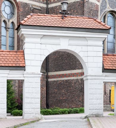 Zdjęcie nr 43: Kościół ceglany, jednonawowy z transeptem. Nawa artykułowana półfilarami i półkolumnami przechodzącymi w gurty sklepienia kolebkowego z lunetami w nawie głównej i żaglowego na przecięciu naw. Na ścianach polichromia na cegle, gurty podkreślone pasami wzorów geometrycznych, sklepienie niebieskie. W nawie i prezbiterium okna w formie biforiów, w transepcie w kształcie stojącego prostokąta zamkniętego łukiem pełnym, z maswerkami, w chórze węższe, zamknięte łukiem ostrym, dwudzielne z rozetą oraz biforia; główne wejście na osi. Chór muzyczny wsparty na masywnych filarach i kolumnach o kapitelach kostkowych z kamiennym parapetem ozdobionym fryzem arkadkowym. Na osi wieloplanowej fasady potężna, trójkondygnacyjna wieża. W pierwszej kondygnacji, po schodach wejście w formie łuku pełnego z drzwiami w formie stojącego prostokąta zamkniętego łukiem dwuramiennym. Obramienie wejścia kamienne, flankowane kolumnami z kostkowymi kapitelami, ze szczytem z chrystogramem. Całość wtopiona w szerszy szczyt, w zwieńczeniu którego rozeta. W trzeciej kondygnacji, zakomponowanej na drugim planie, okno w kształcie stojącego prostokąta zamkniętego łukiem pełnym, dwudzielne z rozetą. Nad nim rzeźba ukrzyżowanego Chrystusa, a w czterech narożach, na konsolach figury św. Stanisława biskupa, św. Stanisława Kostki, św. Jana Kantego i św. Kazimierza Jagiellończyka wykonane z kamienia pińczowskiego przez krakowskiego rzeźbiarza Władysława Druciaka. Wieżę flankują dwie mniejsze, również trójkondygnacyjne wieżyczki dołem czworoboczne, przechodzące w ośmiobok przepruty małymi, prostokątnymi oknami w dwóch niższych kondygnacjach i takimi samymi, naprzemiennie z biforiami w najwyższej. Elewacje transeptu z ogromnymi oknami dekorowanymi maswerkiem, zamknięte trójkątnymi szczytami. Elewacje zewnętrzne z wielobarwnej cegły – w większości ciemnej, dekorowanej na dwóch lub trzech poziomach pasami. Na poziomie pierwszej kondygnacji z jasnej cegły między pasami kamienia, poniżej linii dachu ze wzorem geometrycznym między pasami kamienia, w szczytach jasnym wzorem geometrycznym; chór dekorują blendy arkadkowe. Elewacje opinają ceglane szkarpy, w obejściu zwieńczone kamiennymi kapliczkami. Dachy nawy i transeptu dwuspadowe, dekorowane mozaiką geometryczną, wieloboczna kaplica z dachem sześciokątnym zwieńczonym barokową w kształcie wieżyczką na sygnaturkę, obejście pulpitowym. Do kaplicy przylega przełączka łącząca nowy kościół ze starym.  

Z wyposażenia kościoła na uwagę zasługują obraz Matki Boskiej Suskiej i dwie rzeźby (św. Łukasza i św. Jana Ewangelisty) przeniesione z ołtarza bocznego starego kościoła ustawione na ołtarzu głównym. Sam ołtarz główny (1912) wykonany został przez Antoniego Madeyskiego w Rzymie według rysunków Zygmunta Hendla. Madeyski wykorzystał do wzniesienia ołtarza rzadkie gatunki marmurów z rozebranego starochrześcijańskiego kościoła włoskiego. Niestety przerobiono go i zubożono w 1988 roku. Antoni Madeyski wykonał również tabernakulum, mensę ołtarzową, pulpit oraz chrzcielnicę. Teodor Talowski, architekt, zaprojektował również w 1901 roku ambonę z baldachimem. Zygmunt Hendel zaprojektował, prócz ołtarza głównego, ołtarz boczny św. Józefa i męki Pańskiej (1927). Franciszek Mączyński wykonał figurę Serca Pana Jezusa w latach 1914-1915. Za ołtarzem ze sceną Nawiedzenia widoczne są witraże według kartonów Zdzisława Giedliczki, w prezbiterium ze sceną Zesłania Ducha Świętego i postaciami Matki Boskiej Ostrobramskiej i św. Aleksandra.