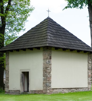 Zdjęcie nr 41: Kościół ceglany, jednonawowy z transeptem. Nawa artykułowana półfilarami i półkolumnami przechodzącymi w gurty sklepienia kolebkowego z lunetami w nawie głównej i żaglowego na przecięciu naw. Na ścianach polichromia na cegle, gurty podkreślone pasami wzorów geometrycznych, sklepienie niebieskie. W nawie i prezbiterium okna w formie biforiów, w transepcie w kształcie stojącego prostokąta zamkniętego łukiem pełnym, z maswerkami, w chórze węższe, zamknięte łukiem ostrym, dwudzielne z rozetą oraz biforia; główne wejście na osi. Chór muzyczny wsparty na masywnych filarach i kolumnach o kapitelach kostkowych z kamiennym parapetem ozdobionym fryzem arkadkowym. Na osi wieloplanowej fasady potężna, trójkondygnacyjna wieża. W pierwszej kondygnacji, po schodach wejście w formie łuku pełnego z drzwiami w formie stojącego prostokąta zamkniętego łukiem dwuramiennym. Obramienie wejścia kamienne, flankowane kolumnami z kostkowymi kapitelami, ze szczytem z chrystogramem. Całość wtopiona w szerszy szczyt, w zwieńczeniu którego rozeta. W trzeciej kondygnacji, zakomponowanej na drugim planie, okno w kształcie stojącego prostokąta zamkniętego łukiem pełnym, dwudzielne z rozetą. Nad nim rzeźba ukrzyżowanego Chrystusa, a w czterech narożach, na konsolach figury św. Stanisława biskupa, św. Stanisława Kostki, św. Jana Kantego i św. Kazimierza Jagiellończyka wykonane z kamienia pińczowskiego przez krakowskiego rzeźbiarza Władysława Druciaka. Wieżę flankują dwie mniejsze, również trójkondygnacyjne wieżyczki dołem czworoboczne, przechodzące w ośmiobok przepruty małymi, prostokątnymi oknami w dwóch niższych kondygnacjach i takimi samymi, naprzemiennie z biforiami w najwyższej. Elewacje transeptu z ogromnymi oknami dekorowanymi maswerkiem, zamknięte trójkątnymi szczytami. Elewacje zewnętrzne z wielobarwnej cegły – w większości ciemnej, dekorowanej na dwóch lub trzech poziomach pasami. Na poziomie pierwszej kondygnacji z jasnej cegły między pasami kamienia, poniżej linii dachu ze wzorem geometrycznym między pasami kamienia, w szczytach jasnym wzorem geometrycznym; chór dekorują blendy arkadkowe. Elewacje opinają ceglane szkarpy, w obejściu zwieńczone kamiennymi kapliczkami. Dachy nawy i transeptu dwuspadowe, dekorowane mozaiką geometryczną, wieloboczna kaplica z dachem sześciokątnym zwieńczonym barokową w kształcie wieżyczką na sygnaturkę, obejście pulpitowym. Do kaplicy przylega przełączka łącząca nowy kościół ze starym.  

Z wyposażenia kościoła na uwagę zasługują obraz Matki Boskiej Suskiej i dwie rzeźby (św. Łukasza i św. Jana Ewangelisty) przeniesione z ołtarza bocznego starego kościoła ustawione na ołtarzu głównym. Sam ołtarz główny (1912) wykonany został przez Antoniego Madeyskiego w Rzymie według rysunków Zygmunta Hendla. Madeyski wykorzystał do wzniesienia ołtarza rzadkie gatunki marmurów z rozebranego starochrześcijańskiego kościoła włoskiego. Niestety przerobiono go i zubożono w 1988 roku. Antoni Madeyski wykonał również tabernakulum, mensę ołtarzową, pulpit oraz chrzcielnicę. Teodor Talowski, architekt, zaprojektował również w 1901 roku ambonę z baldachimem. Zygmunt Hendel zaprojektował, prócz ołtarza głównego, ołtarz boczny św. Józefa i męki Pańskiej (1927). Franciszek Mączyński wykonał figurę Serca Pana Jezusa w latach 1914-1915. Za ołtarzem ze sceną Nawiedzenia widoczne są witraże według kartonów Zdzisława Giedliczki, w prezbiterium ze sceną Zesłania Ducha Świętego i postaciami Matki Boskiej Ostrobramskiej i św. Aleksandra.