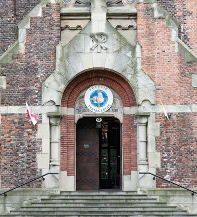 Zdjęcie nr 55: Kościół ceglany, jednonawowy z transeptem. Nawa artykułowana półfilarami i półkolumnami przechodzącymi w gurty sklepienia kolebkowego z lunetami w nawie głównej i żaglowego na przecięciu naw. Na ścianach polichromia na cegle, gurty podkreślone pasami wzorów geometrycznych, sklepienie niebieskie. W nawie i prezbiterium okna w formie biforiów, w transepcie w kształcie stojącego prostokąta zamkniętego łukiem pełnym, z maswerkami, w chórze węższe, zamknięte łukiem ostrym, dwudzielne z rozetą oraz biforia; główne wejście na osi. Chór muzyczny wsparty na masywnych filarach i kolumnach o kapitelach kostkowych z kamiennym parapetem ozdobionym fryzem arkadkowym. Na osi wieloplanowej fasady potężna, trójkondygnacyjna wieża. W pierwszej kondygnacji, po schodach wejście w formie łuku pełnego z drzwiami w formie stojącego prostokąta zamkniętego łukiem dwuramiennym. Obramienie wejścia kamienne, flankowane kolumnami z kostkowymi kapitelami, ze szczytem z chrystogramem. Całość wtopiona w szerszy szczyt, w zwieńczeniu którego rozeta. W trzeciej kondygnacji, zakomponowanej na drugim planie, okno w kształcie stojącego prostokąta zamkniętego łukiem pełnym, dwudzielne z rozetą. Nad nim rzeźba ukrzyżowanego Chrystusa, a w czterech narożach, na konsolach figury św. Stanisława biskupa, św. Stanisława Kostki, św. Jana Kantego i św. Kazimierza Jagiellończyka wykonane z kamienia pińczowskiego przez krakowskiego rzeźbiarza Władysława Druciaka. Wieżę flankują dwie mniejsze, również trójkondygnacyjne wieżyczki dołem czworoboczne, przechodzące w ośmiobok przepruty małymi, prostokątnymi oknami w dwóch niższych kondygnacjach i takimi samymi, naprzemiennie z biforiami w najwyższej. Elewacje transeptu z ogromnymi oknami dekorowanymi maswerkiem, zamknięte trójkątnymi szczytami. Elewacje zewnętrzne z wielobarwnej cegły – w większości ciemnej, dekorowanej na dwóch lub trzech poziomach pasami. Na poziomie pierwszej kondygnacji z jasnej cegły między pasami kamienia, poniżej linii dachu ze wzorem geometrycznym między pasami kamienia, w szczytach jasnym wzorem geometrycznym; chór dekorują blendy arkadkowe. Elewacje opinają ceglane szkarpy, w obejściu zwieńczone kamiennymi kapliczkami. Dachy nawy i transeptu dwuspadowe, dekorowane mozaiką geometryczną, wieloboczna kaplica z dachem sześciokątnym zwieńczonym barokową w kształcie wieżyczką na sygnaturkę, obejście pulpitowym. Do kaplicy przylega przełączka łącząca nowy kościół ze starym.  

Z wyposażenia kościoła na uwagę zasługują obraz Matki Boskiej Suskiej i dwie rzeźby (św. Łukasza i św. Jana Ewangelisty) przeniesione z ołtarza bocznego starego kościoła ustawione na ołtarzu głównym. Sam ołtarz główny (1912) wykonany został przez Antoniego Madeyskiego w Rzymie według rysunków Zygmunta Hendla. Madeyski wykorzystał do wzniesienia ołtarza rzadkie gatunki marmurów z rozebranego starochrześcijańskiego kościoła włoskiego. Niestety przerobiono go i zubożono w 1988 roku. Antoni Madeyski wykonał również tabernakulum, mensę ołtarzową, pulpit oraz chrzcielnicę. Teodor Talowski, architekt, zaprojektował również w 1901 roku ambonę z baldachimem. Zygmunt Hendel zaprojektował, prócz ołtarza głównego, ołtarz boczny św. Józefa i męki Pańskiej (1927). Franciszek Mączyński wykonał figurę Serca Pana Jezusa w latach 1914-1915. Za ołtarzem ze sceną Nawiedzenia widoczne są witraże według kartonów Zdzisława Giedliczki, w prezbiterium ze sceną Zesłania Ducha Świętego i postaciami Matki Boskiej Ostrobramskiej i św. Aleksandra.