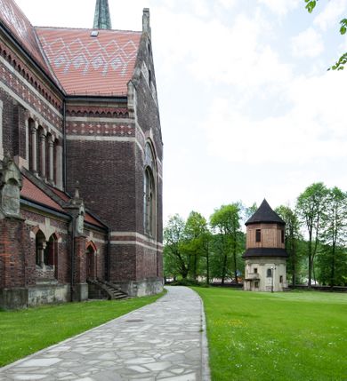 Zdjęcie nr 22: Kościół ceglany, jednonawowy z transeptem. Nawa artykułowana półfilarami i półkolumnami przechodzącymi w gurty sklepienia kolebkowego z lunetami w nawie głównej i żaglowego na przecięciu naw. Na ścianach polichromia na cegle, gurty podkreślone pasami wzorów geometrycznych, sklepienie niebieskie. W nawie i prezbiterium okna w formie biforiów, w transepcie w kształcie stojącego prostokąta zamkniętego łukiem pełnym, z maswerkami, w chórze węższe, zamknięte łukiem ostrym, dwudzielne z rozetą oraz biforia; główne wejście na osi. Chór muzyczny wsparty na masywnych filarach i kolumnach o kapitelach kostkowych z kamiennym parapetem ozdobionym fryzem arkadkowym. Na osi wieloplanowej fasady potężna, trójkondygnacyjna wieża. W pierwszej kondygnacji, po schodach wejście w formie łuku pełnego z drzwiami w formie stojącego prostokąta zamkniętego łukiem dwuramiennym. Obramienie wejścia kamienne, flankowane kolumnami z kostkowymi kapitelami, ze szczytem z chrystogramem. Całość wtopiona w szerszy szczyt, w zwieńczeniu którego rozeta. W trzeciej kondygnacji, zakomponowanej na drugim planie, okno w kształcie stojącego prostokąta zamkniętego łukiem pełnym, dwudzielne z rozetą. Nad nim rzeźba ukrzyżowanego Chrystusa, a w czterech narożach, na konsolach figury św. Stanisława biskupa, św. Stanisława Kostki, św. Jana Kantego i św. Kazimierza Jagiellończyka wykonane z kamienia pińczowskiego przez krakowskiego rzeźbiarza Władysława Druciaka. Wieżę flankują dwie mniejsze, również trójkondygnacyjne wieżyczki dołem czworoboczne, przechodzące w ośmiobok przepruty małymi, prostokątnymi oknami w dwóch niższych kondygnacjach i takimi samymi, naprzemiennie z biforiami w najwyższej. Elewacje transeptu z ogromnymi oknami dekorowanymi maswerkiem, zamknięte trójkątnymi szczytami. Elewacje zewnętrzne z wielobarwnej cegły – w większości ciemnej, dekorowanej na dwóch lub trzech poziomach pasami. Na poziomie pierwszej kondygnacji z jasnej cegły między pasami kamienia, poniżej linii dachu ze wzorem geometrycznym między pasami kamienia, w szczytach jasnym wzorem geometrycznym; chór dekorują blendy arkadkowe. Elewacje opinają ceglane szkarpy, w obejściu zwieńczone kamiennymi kapliczkami. Dachy nawy i transeptu dwuspadowe, dekorowane mozaiką geometryczną, wieloboczna kaplica z dachem sześciokątnym zwieńczonym barokową w kształcie wieżyczką na sygnaturkę, obejście pulpitowym. Do kaplicy przylega przełączka łącząca nowy kościół ze starym.  

Z wyposażenia kościoła na uwagę zasługują obraz Matki Boskiej Suskiej i dwie rzeźby (św. Łukasza i św. Jana Ewangelisty) przeniesione z ołtarza bocznego starego kościoła ustawione na ołtarzu głównym. Sam ołtarz główny (1912) wykonany został przez Antoniego Madeyskiego w Rzymie według rysunków Zygmunta Hendla. Madeyski wykorzystał do wzniesienia ołtarza rzadkie gatunki marmurów z rozebranego starochrześcijańskiego kościoła włoskiego. Niestety przerobiono go i zubożono w 1988 roku. Antoni Madeyski wykonał również tabernakulum, mensę ołtarzową, pulpit oraz chrzcielnicę. Teodor Talowski, architekt, zaprojektował również w 1901 roku ambonę z baldachimem. Zygmunt Hendel zaprojektował, prócz ołtarza głównego, ołtarz boczny św. Józefa i męki Pańskiej (1927). Franciszek Mączyński wykonał figurę Serca Pana Jezusa w latach 1914-1915. Za ołtarzem ze sceną Nawiedzenia widoczne są witraże według kartonów Zdzisława Giedliczki, w prezbiterium ze sceną Zesłania Ducha Świętego i postaciami Matki Boskiej Ostrobramskiej i św. Aleksandra.