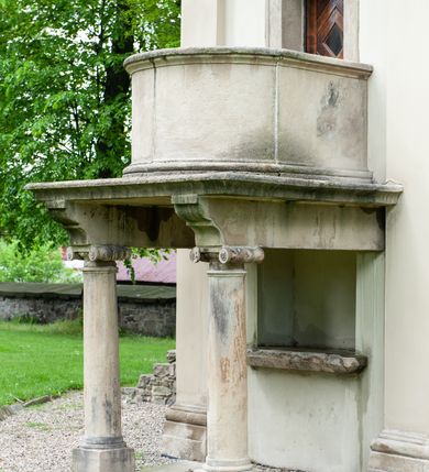 Zdjęcie nr 6: Kaplica na planie ośmioboku, dwukondygnacyjna, z dolną kondygnacją murowaną, a górną drewnianą w konstrukcji słupowej, szalowaną deskami. 
Część dolna została wybudowana z kamienia łamanego, otynkowana i mieści kaplicę nakrytą sklepieniem kopulastym z lunetami (?) oraz kryptę grobową. Ściany zewnętrzne ujęte są w narożach pilastrami toskańskimi dźwigającymi belkowanie. Od wschodu i zachodu prostokątne wejścia do kaplicy po schodach, od południowego-zachodu wejście do krypty zamknięte półkolem, po przeciwnej stronie takie samo zamurowane. Od południa ambona wsparta na dwóch jońskich kolumnach. Kaplicę oświetlają duże okna zamknięte półkolem, kryptę małe okrągłe, obecnie ślepe. Nad gzymsem koronującym okap gontowy, górna część nakryta stożkowym dachem gontowym. 
