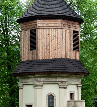 Zdjęcie nr 5: Kaplica na planie ośmioboku, dwukondygnacyjna, z dolną kondygnacją murowaną, a górną drewnianą w konstrukcji słupowej, szalowaną deskami. 
Część dolna została wybudowana z kamienia łamanego, otynkowana i mieści kaplicę nakrytą sklepieniem kopulastym z lunetami (?) oraz kryptę grobową. Ściany zewnętrzne ujęte są w narożach pilastrami toskańskimi dźwigającymi belkowanie. Od wschodu i zachodu prostokątne wejścia do kaplicy po schodach, od południowego-zachodu wejście do krypty zamknięte półkolem, po przeciwnej stronie takie samo zamurowane. Od południa ambona wsparta na dwóch jońskich kolumnach. Kaplicę oświetlają duże okna zamknięte półkolem, kryptę małe okrągłe, obecnie ślepe. Nad gzymsem koronującym okap gontowy, górna część nakryta stożkowym dachem gontowym. 
