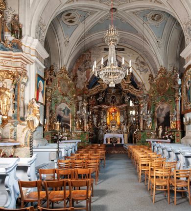 Zdjęcie nr 17: Orientowany, na rzucie prostokąta, jednonawowy, trójprzęsłowy, z węższym jednoprzęsłowym zamkniętym wielobocznie prezbiterium, przy którym od północy prostokątna zakrystia; przy nawie od południa kruchta, od północy kaplica Matki Boskiej Bolesnej, na rzucie prostokąta, ze ścianą północną wybrzuszoną w połowie długości. Od zachodu przy kaplicy wieża z prostokątną przybudówką od południa. W prezbiterium sklepienie krzyżowo-żebrowe z cylindrycznymi zwornikami wiązanymi z rodem Berzeviczych; w nawie kolebkowe z lunetami na filarach przyściennych. Arkada tęczy ostrołukowa. Zewnątrz mury opięte uskokowymi przyporami. Okna ostrołukowe dwudzielne, z maswerkami. W kruchcie południowej portal do nawy kamienny, ostrołukowy. Portal do kruchty neogotycki. Dach nad nawą dwuspadowy, na kalenicy pseudogotycka wieżyczka na sygnaturkę; dach prezbiterium wielopołaciowy.   