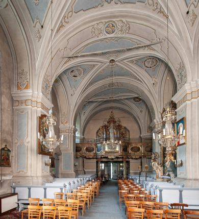 Zdjęcie nr 19: Orientowany, na rzucie prostokąta, jednonawowy, trójprzęsłowy, z węższym jednoprzęsłowym zamkniętym wielobocznie prezbiterium, przy którym od północy prostokątna zakrystia; przy nawie od południa kruchta, od północy kaplica Matki Boskiej Bolesnej, na rzucie prostokąta, ze ścianą północną wybrzuszoną w połowie długości. Od zachodu przy kaplicy wieża z prostokątną przybudówką od południa. W prezbiterium sklepienie krzyżowo-żebrowe z cylindrycznymi zwornikami wiązanymi z rodem Berzeviczych; w nawie kolebkowe z lunetami na filarach przyściennych. Arkada tęczy ostrołukowa. Zewnątrz mury opięte uskokowymi przyporami. Okna ostrołukowe dwudzielne, z maswerkami. W kruchcie południowej portal do nawy kamienny, ostrołukowy. Portal do kruchty neogotycki. Dach nad nawą dwuspadowy, na kalenicy pseudogotycka wieżyczka na sygnaturkę; dach prezbiterium wielopołaciowy.   