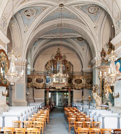 Zdjęcie nr 18: Orientowany, na rzucie prostokąta, jednonawowy, trójprzęsłowy, z węższym jednoprzęsłowym zamkniętym wielobocznie prezbiterium, przy którym od północy prostokątna zakrystia; przy nawie od południa kruchta, od północy kaplica Matki Boskiej Bolesnej, na rzucie prostokąta, ze ścianą północną wybrzuszoną w połowie długości. Od zachodu przy kaplicy wieża z prostokątną przybudówką od południa. W prezbiterium sklepienie krzyżowo-żebrowe z cylindrycznymi zwornikami wiązanymi z rodem Berzeviczych; w nawie kolebkowe z lunetami na filarach przyściennych. Arkada tęczy ostrołukowa. Zewnątrz mury opięte uskokowymi przyporami. Okna ostrołukowe dwudzielne, z maswerkami. W kruchcie południowej portal do nawy kamienny, ostrołukowy. Portal do kruchty neogotycki. Dach nad nawą dwuspadowy, na kalenicy pseudogotycka wieżyczka na sygnaturkę; dach prezbiterium wielopołaciowy.   