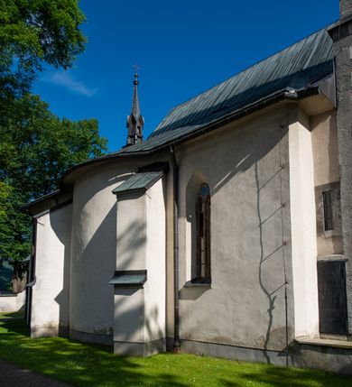 Zdjęcie nr 11: Orientowany, na rzucie prostokąta, jednonawowy, trójprzęsłowy, z węższym jednoprzęsłowym zamkniętym wielobocznie prezbiterium, przy którym od północy prostokątna zakrystia; przy nawie od południa kruchta, od północy kaplica Matki Boskiej Bolesnej, na rzucie prostokąta, ze ścianą północną wybrzuszoną w połowie długości. Od zachodu przy kaplicy wieża z prostokątną przybudówką od południa. W prezbiterium sklepienie krzyżowo-żebrowe z cylindrycznymi zwornikami wiązanymi z rodem Berzeviczych; w nawie kolebkowe z lunetami na filarach przyściennych. Arkada tęczy ostrołukowa. Zewnątrz mury opięte uskokowymi przyporami. Okna ostrołukowe dwudzielne, z maswerkami. W kruchcie południowej portal do nawy kamienny, ostrołukowy. Portal do kruchty neogotycki. Dach nad nawą dwuspadowy, na kalenicy pseudogotycka wieżyczka na sygnaturkę; dach prezbiterium wielopołaciowy.   