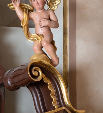 Zdjęcie nr 8: Ołtarz architektoniczny, jednokondygnacyjny, jednoosiowy, ze zwieńczeniem. Ołtarz murowany, prostopadłościenny z drewnianym antepedium ujętym drewnianą, profilowaną ramą. W polu, na błękitnym tle polichromowana para aniołków unoszących godło herbu papieskiego. Retabulum osadzone na niewysokim, zryzalitowanym uskokowo cokole. Część środkową ujmują dwie pary kolumn o cylindrycznych, kanelowanych trzonach, wspierających wyłamujące się ponad nimi, przerwane w partii architrawu i fryzu belkowanie. Zwieńczenie ujęte parą spływów wolutowych i zamknięte parą stykających się wolut, po bokach przerwany przyczółek w formie wolut. Część środkową retabulum zdobią motywy akantu i ujmuje para ażurowych uszaków. Na fryzie umieszczono kampanule. Pośrodku zwieńczenia racaille’owy kartusz, natomiast krawędzie zdobią akantowe gałązki. Szczyt w formie impostu z motywem konchy. Pole środkowe retabulum w kształcie stojącego prostokąta zamkniętego łukiem nadwieszonym z uskokami, ujęte profilowaną, złoconą ramą. W środku obraz Św. Anny, na zasuwie św. Michał Archanioł. Po bokach części środkowej para ustawionych na konsolach figur św. Piotra po lewej i św. Pawła po prawej stronie. W zwieńczeniu obraz w kształcie zbliżonym do kwadratu o wklęsłych narożach z przedstawieniem „Nawiedzenia św. Elżbiety”, po bokach para aniołków. Struktura ołtarza w kolorze brązowym, detal architektoniczny i ornamentyka złocone, rzeźby polichromowane.    