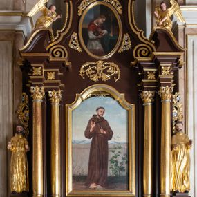 Zdjęcie nr 1: Ołtarz architektoniczny, jednokondygnacyjny, jednoosiowy, ze zwieńczeniem. Ołtarz prostopadłościenny, z drewnianą mensą. Antepedium ujęte profilowaną, polichromowaną ramą zdobioną ornamentyką roślinną. Błękitne pole ujęte jest kwietną bordiurą, pośrodku polichromowana dekoracja w formie inicjałów AS wplecionych w kwiaty białych lilii. Retabulum osadzone na wysokim, zdwojonym cokole, ujęte dwiema parami kolumn, z których zewnętrzne wysunięte do przodu, ustawionych na tle zdwojonych pilastrów. Podpory podtrzymują przerwane, wyłamujące się ponad nimi belkowanie. Zwieńczenie ujęte parą spływów wolutowych i zamknięte nadwieszonym łukiem odcinkowym. Po bokach ujęte przerwanym, wolutowym przyczółkiem. Pola cokołu retabulum zdobią płyciny z wydłużonymi rozetami, pośrodku kompozycja z wici akantu z rozetką. Część środkową retabulum ujmuje para ażurowych uszaków rocaille’owych z motywami rozetek. W partii przerwanego belkowania jest ornament roślinnego z motywem chrząstki, we fryzie rozety. Pole zwieńczenia zdobi stylizowana ornamentyka roślinna, gzyms motyw astragalu. Szczyt w formie ażurowej konchy ujętej po bokach parą wazonów z kwiatami słonecznika. Na przerwanym przyczółku para aniołków w złoconych szatach. Pole części środkowej w kształcie stojącego prostokąta zamkniętego półkolistym łukiem nadwieszonym z uskokami, ujęte profilowaną, złocono-srebrzoną ramą, z przedstawieniem św. Antoniego Padewskiego, na zasuwie obraz św. Franciszka z Asyżu. Retabulum ujmuje para figur niezidentyfikowanych świętych zakonników. W polu zwieńczenia, w owalnej ramie obraz  św. Roberta Bellarmina. Struktura w kolorze ciemnobrązowym, detal architektoniczny i ornamentyka złocone i posrebrzane.