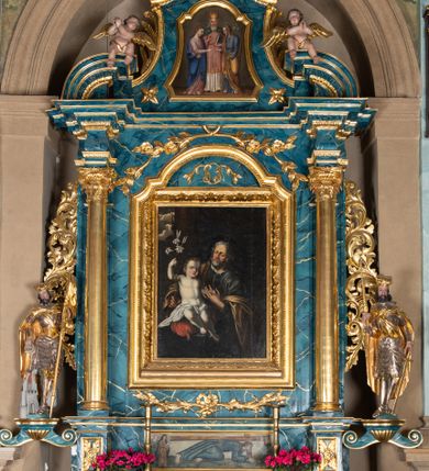 Zdjęcie nr 1: Ołtarz architektoniczny, jednokondygnacyjny, jednoosiowy ze zwieńczeniem. Ołtarz prostopadłościenny, murowany z drewnianą mensą. Antepedium drewniane, w formie leżącego prostokąta ujętego ramą, z przedstawieniem śmierci św. Józefa w oktogonalnym  polu, po bokach rodzina fundatorów. Retabulum osadzone na niewysokim, zryzalitowanym po bokach cokole. Część środkową nastawy ujmuje para kolumn wspierających przerwane w partii architrawu i wybrzuszonego fryzu belkowanie z silnie wysuniętym gzymsem. Zwieńczenie ujęte parą spływów i zamknięte fragmentem gzymsu w kształcie wklęsło-wypukłego łuku. Po bokach przerwany, półkolisty przyczółek. Pola cokołu zdobi motyw wydłużonych rozet, dolną partię części środkowej retabulum para związanych kokardą gałązek laurowych, nad obrazem sygle „SJ” wkomponowane w ulistnione gałązki, natomiast w górnej partii para spiętych gałązek różanych z kwiatkami. Boki retabulum ujmuje para ażurowych uszaków akantowych. Krawędzie spływów zwieńczenia zdobią ulistnione gałązki, w dolnej części para rozet, u góry uskrzydlona główka anielska. Szczyt w formie palmety. Na przerwanym przyczółku para aniołków. Pośrodku cokołu retabulum obraz w kształcie leżącego prostokąta, ujęty wąską złoconą ramą, z przedstawieniem Jezusa upadającego pod krzyżem. Pole części środkowej ołtarza w kształcie stojącego prostokąta zamkniętego półkolistym łukiem nadwieszonym z uskokami, ujęte profilowaną, złoconą ramą. W środku obraz w kształcie stojącego prostokąta, w złoconej ramie zdobionej motywem liści akantu, z przedstawieniem św. Józefa. Po bokach retabulum para rzeźb ustawionych na niewysokich konsolach wspartych na parze wolut, po prawej stronie wizerunek św. Wacława, po lewej św. Floriana. Pole środkowe zwieńczenia w kształcie trapezu o wklęsłych ramionach i narożach, zamkniętego półkolistym łukiem nadwieszonym, ujęte profilowaną, złoconą ramą, z przedstawieniem zaślubin Marii i św. Józefa. Struktura w całości marmoryzowana w kolorze zielono-niebieskim, detal architektoniczny i ornamentyka złocone.