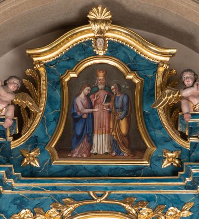 Zdjęcie nr 3: Ołtarz architektoniczny, jednokondygnacyjny, jednoosiowy ze zwieńczeniem. Ołtarz prostopadłościenny, murowany z drewnianą mensą. Antepedium drewniane, w formie leżącego prostokąta ujętego ramą, z przedstawieniem śmierci św. Józefa w oktogonalnym  polu, po bokach rodzina fundatorów. Retabulum osadzone na niewysokim, zryzalitowanym po bokach cokole. Część środkową nastawy ujmuje para kolumn wspierających przerwane w partii architrawu i wybrzuszonego fryzu belkowanie z silnie wysuniętym gzymsem. Zwieńczenie ujęte parą spływów i zamknięte fragmentem gzymsu w kształcie wklęsło-wypukłego łuku. Po bokach przerwany, półkolisty przyczółek. Pola cokołu zdobi motyw wydłużonych rozet, dolną partię części środkowej retabulum para związanych kokardą gałązek laurowych, nad obrazem sygle „SJ” wkomponowane w ulistnione gałązki, natomiast w górnej partii para spiętych gałązek różanych z kwiatkami. Boki retabulum ujmuje para ażurowych uszaków akantowych. Krawędzie spływów zwieńczenia zdobią ulistnione gałązki, w dolnej części para rozet, u góry uskrzydlona główka anielska. Szczyt w formie palmety. Na przerwanym przyczółku para aniołków. Pośrodku cokołu retabulum obraz w kształcie leżącego prostokąta, ujęty wąską złoconą ramą, z przedstawieniem Jezusa upadającego pod krzyżem. Pole części środkowej ołtarza w kształcie stojącego prostokąta zamkniętego półkolistym łukiem nadwieszonym z uskokami, ujęte profilowaną, złoconą ramą. W środku obraz w kształcie stojącego prostokąta, w złoconej ramie zdobionej motywem liści akantu, z przedstawieniem św. Józefa. Po bokach retabulum para rzeźb ustawionych na niewysokich konsolach wspartych na parze wolut, po prawej stronie wizerunek św. Wacława, po lewej św. Floriana. Pole środkowe zwieńczenia w kształcie trapezu o wklęsłych ramionach i narożach, zamkniętego półkolistym łukiem nadwieszonym, ujęte profilowaną, złoconą ramą, z przedstawieniem zaślubin Marii i św. Józefa. Struktura w całości marmoryzowana w kolorze zielono-niebieskim, detal architektoniczny i ornamentyka złocone.