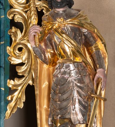 Zdjęcie nr 7: Ołtarz architektoniczny, jednokondygnacyjny, jednoosiowy ze zwieńczeniem. Ołtarz prostopadłościenny, murowany z drewnianą mensą. Antepedium drewniane, w formie leżącego prostokąta ujętego ramą, z przedstawieniem śmierci św. Józefa w oktogonalnym  polu, po bokach rodzina fundatorów. Retabulum osadzone na niewysokim, zryzalitowanym po bokach cokole. Część środkową nastawy ujmuje para kolumn wspierających przerwane w partii architrawu i wybrzuszonego fryzu belkowanie z silnie wysuniętym gzymsem. Zwieńczenie ujęte parą spływów i zamknięte fragmentem gzymsu w kształcie wklęsło-wypukłego łuku. Po bokach przerwany, półkolisty przyczółek. Pola cokołu zdobi motyw wydłużonych rozet, dolną partię części środkowej retabulum para związanych kokardą gałązek laurowych, nad obrazem sygle „SJ” wkomponowane w ulistnione gałązki, natomiast w górnej partii para spiętych gałązek różanych z kwiatkami. Boki retabulum ujmuje para ażurowych uszaków akantowych. Krawędzie spływów zwieńczenia zdobią ulistnione gałązki, w dolnej części para rozet, u góry uskrzydlona główka anielska. Szczyt w formie palmety. Na przerwanym przyczółku para aniołków. Pośrodku cokołu retabulum obraz w kształcie leżącego prostokąta, ujęty wąską złoconą ramą, z przedstawieniem Jezusa upadającego pod krzyżem. Pole części środkowej ołtarza w kształcie stojącego prostokąta zamkniętego półkolistym łukiem nadwieszonym z uskokami, ujęte profilowaną, złoconą ramą. W środku obraz w kształcie stojącego prostokąta, w złoconej ramie zdobionej motywem liści akantu, z przedstawieniem św. Józefa. Po bokach retabulum para rzeźb ustawionych na niewysokich konsolach wspartych na parze wolut, po prawej stronie wizerunek św. Wacława, po lewej św. Floriana. Pole środkowe zwieńczenia w kształcie trapezu o wklęsłych ramionach i narożach, zamkniętego półkolistym łukiem nadwieszonym, ujęte profilowaną, złoconą ramą, z przedstawieniem zaślubin Marii i św. Józefa. Struktura w całości marmoryzowana w kolorze zielono-niebieskim, detal architektoniczny i ornamentyka złocone.