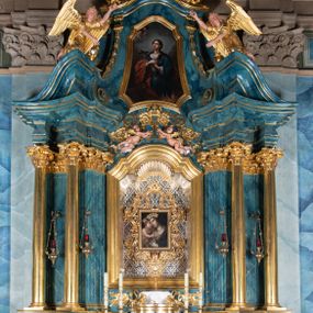 Zdjęcie nr 1: Ołtarz architektoniczny, jednokondygnacyjny, jednoosiowy ze zwieńczeniem. Ołtarz drewniany, prostopadłościenny, ustawiony na dwustopniowej podstawie. Antependium w formie leżącego prostokąta ujętego ramą dekorowaną akantem; w polu owalny medalion w wieńcu z monogramem maryjnym, wkomponowany w gęste wici suchego akantu.
Tabernakulum w formie drewnianej skrzynki na cokole o wklęsło-wypukłym licu, ujęte dwoma parami pilastrów o trzonach utworzonych z podwójnych spływów wolutowych; dźwigających pełne belkowanie opasujące ściankę frontową, wyłamane na osi podpór. Drzwiczki w formie stojącego prostokąta zamkniętego łukiem półkolistym nadwieszonym z krzyżem w polu, na którego przecięciu ramion medalion z monogramem imienia Jezus w glorii. Tron wystawienia w postaci podestu wspartego na pięciu kabłąkach. Struktura w całości srebrzona, podpory i profile złocone.
Nastawa osadzona na zdwojonym cokole, górny lekko wybrzuszony. Część środkowa ujęta parą pilastrów o kanelowanych trzonach i kapitelach kompozytowych zwróconych do wewnątrz lica ołtarza oraz trzema parami analogicznych pilastrów ustawionych pod kątem na zewnątrz przed którymi stoją dwie pary kolumn o kapitelach kompozytowych. Podpory dźwigają pełne belkowanie, przerwane belkowanie o lekko wybrzuszonym fryzie i wklęsłej linii gzymsu. Zwieńczenie ujęte parą spływów wolutowych i zamknięte fragmentem gzymsu w postaci łuku wklęsło-wypukłego. Całość flankuje przerwany, ustawiony skośnie, falisty przyczółek. Pole przerwanego belkowania wypełnia schweifwerk przechodzący w wić roślinną z motywami rozet oraz parą puttów podtrzymujących koronę. Spływy wolutowe zwieńczenia zdobią kampanule, oraz para wazonów, gzyms wieńczący zaś trzy konchy. Na przerwanym przyczółku para figur klęczących aniołów.  Pole części środkowej retabulum w formie głębokiej niszy w kształcie stojącego prostokąta zamkniętego łukiem odcinkowym łukiem nadwieszonym z uskokami, ujętej profilowaną ramą, we wnątrz znajduje się obraz Matki Boskiej Myślenickiej. W zwieńczeniu obraz w kształcie trapezu o wklęsłych ramionach, podstawie i narożach zamknięty łukiem wklęsło-wypukłym, ujęty profilowaną ramą, z wizerunkiem św. Tekli. 
Struktura w całości marmoryzowana w kolorze zielono-granatowym; kolumny, ornamentyka i profile złocone i srebrzone.
