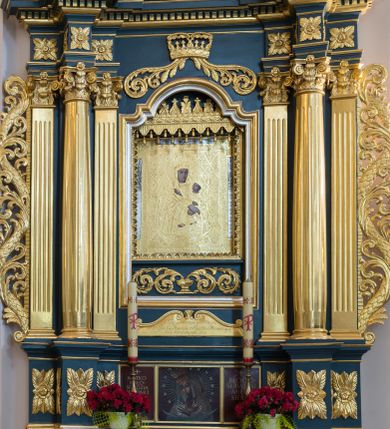 Zdjęcie nr 1: Ołtarz architektoniczny, jednokondygnacyjny, jednoosiowy, ze zwieńczeniem. Ołtarz drewniany, sarkofagowy, z dostawionym prostokątnym, drewnianym antepedium. Pole antepedium zdobione dekoracją polichromowaną na błękitnym tle, z formą kartusza z monogramem maryjnym pośrodku, ujętym ornamentyką akantową oraz parą aniołków. Retabulum na zdwojonym cokole o zryzalitowanych, lekko ukośnie ustawionych bokach, ujęte dwoma parami pilastrów i parą kolumn korynckich o żłobkowanych trzonach, wspierających wyłamujące się ponad nimi, przerwane w partii architrawu i fryzu belkowanie z silnie wysuniętym gzymsem. Zwieńczenie w formie stojącego prostokąta ujętego po bokach parą spływów wolutowych, zamknięte parą przeciwstawnie ustawionych, stykających się wolut. Szczyt w formie okrągłej, ażurowej, promienistej glorii z monogramem maryjnym. Zwieńczenie flankowane przerwanym wolutowym przyczółkiem oraz parą wazonów. Pola boczne cokołu retabulum zdobione motywem wydłużonych rozet. W polu środkowym trójdzielna płycina w kształcie leżącego prostokąta, z wizerunkiem Matki Boskiej Ostrobramskiej oraz napisem „MATKO MIŁO/SIERDZIA / PRZYJMIJ / NASZE / CIERPIENIA / 1994 / + BŁOGO/SŁAWIENI / MIŁO/SIERNI”.  Retabulum ujęte parą ażurowych, akantowych uszaków z wplecionym motywem liści laurowych. W dolnej partii środkowej części retabulum płycina o fantazyjnym wykroju z inskrypcją „Fondatorowie Ułtarza / Woyciech y Agniszka z Łopatów Mrowczeńscy / dnia 5go Listopada 1827”.  W górnej części zamknięta korona z podwieszoną parą wolut w formie stylizowanej wici roślinnej. W dolnej partii wnęki retabulum wazon z wolutowo kształtującymi się wiciami akantowymi, u góry motyw lambrekinu. Części fryzu retabulum zdobione rozetami. W partii gzymsu ornament kostkowy. Spływy wolutowe zwieńczenia zdobione grzebieniem rocaille&#039;owym oraz gałązką laurową. W górnej partii zwieńczenia motyw dwóch gałązek różanych. Całość flankowana parą wazonów z kwiatem lilii. Pole środkowe w formie wnęki w kształcie stojącego prostokąta zamkniętego łukiem wycinkowym uskokowym, nadwieszonym, ujęte profilowaną złoconą i srebrzoną ramą. Wewnątrz obraz Matki Boskiej Szkaplerznej.  W zwieńczeniu pole w kształcie trapezu o wklęsłych ramionach i podstawie, zamkniętego łukiem kotarowym, ujęte profilowaną, srebrzoną ramą. Wewnątrz obraz św. Agnieszki. Na przerwanym przyczółku para klęczących aniołków. 
Struktura polichromowana w odcieniu ciemnego turkusu. Detal architektoniczny i ornamentyka złocone oraz srebrzone. 