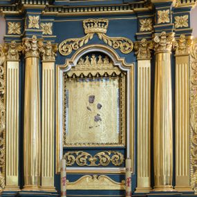 Zdjęcie nr 1: Ołtarz architektoniczny, jednokondygnacyjny, jednoosiowy, ze zwieńczeniem. Ołtarz drewniany, sarkofagowy, z dostawionym prostokątnym, drewnianym antepedium. Pole antepedium zdobione dekoracją polichromowaną na błękitnym tle, z formą kartusza z monogramem maryjnym pośrodku, ujętym ornamentyką akantową oraz parą aniołków. Retabulum na zdwojonym cokole o zryzalitowanych, lekko ukośnie ustawionych bokach, ujęte dwoma parami pilastrów i parą kolumn korynckich o żłobkowanych trzonach, wspierających wyłamujące się ponad nimi, przerwane w partii architrawu i fryzu belkowanie z silnie wysuniętym gzymsem. Zwieńczenie w formie stojącego prostokąta ujętego po bokach parą spływów wolutowych, zamknięte parą przeciwstawnie ustawionych, stykających się wolut. Szczyt w formie okrągłej, ażurowej, promienistej glorii z monogramem maryjnym. Zwieńczenie flankowane przerwanym wolutowym przyczółkiem oraz parą wazonów. Pola boczne cokołu retabulum zdobione motywem wydłużonych rozet. W polu środkowym trójdzielna płycina w kształcie leżącego prostokąta, z wizerunkiem Matki Boskiej Ostrobramskiej oraz napisem „MATKO MIŁO/SIERDZIA / PRZYJMIJ / NASZE / CIERPIENIA / 1994 / + BŁOGO/SŁAWIENI / MIŁO/SIERNI”.  Retabulum ujęte parą ażurowych, akantowych uszaków z wplecionym motywem liści laurowych. W dolnej partii środkowej części retabulum płycina o fantazyjnym wykroju z inskrypcją „Fondatorowie Ułtarza / Woyciech y Agniszka z Łopatów Mrowczeńscy / dnia 5go Listopada 1827”.  W górnej części zamknięta korona z podwieszoną parą wolut w formie stylizowanej wici roślinnej. W dolnej partii wnęki retabulum wazon z wolutowo kształtującymi się wiciami akantowymi, u góry motyw lambrekinu. Części fryzu retabulum zdobione rozetami. W partii gzymsu ornament kostkowy. Spływy wolutowe zwieńczenia zdobione grzebieniem rocaille'owym oraz gałązką laurową. W górnej partii zwieńczenia motyw dwóch gałązek różanych. Całość flankowana parą wazonów z kwiatem lilii. Pole środkowe w formie wnęki w kształcie stojącego prostokąta zamkniętego łukiem wycinkowym uskokowym, nadwieszonym, ujęte profilowaną złoconą i srebrzoną ramą. Wewnątrz obraz Matki Boskiej Szkaplerznej.  W zwieńczeniu pole w kształcie trapezu o wklęsłych ramionach i podstawie, zamkniętego łukiem kotarowym, ujęte profilowaną, srebrzoną ramą. Wewnątrz obraz św. Agnieszki. Na przerwanym przyczółku para klęczących aniołków. 
Struktura polichromowana w odcieniu ciemnego turkusu. Detal architektoniczny i ornamentyka złocone oraz srebrzone. 